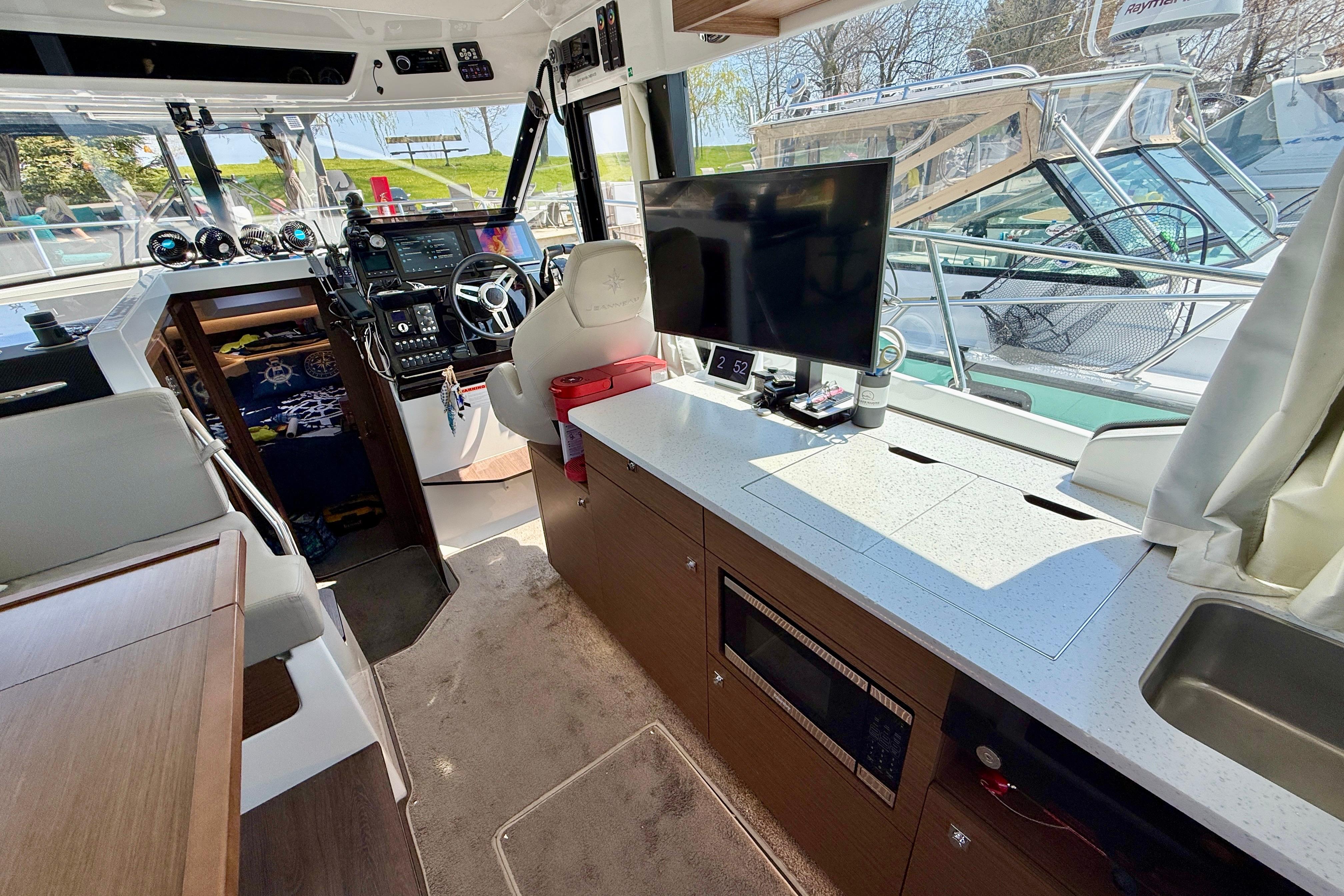Interior of 2022 Jeanneau NC 1095 Fly boat with modern helm and galley.