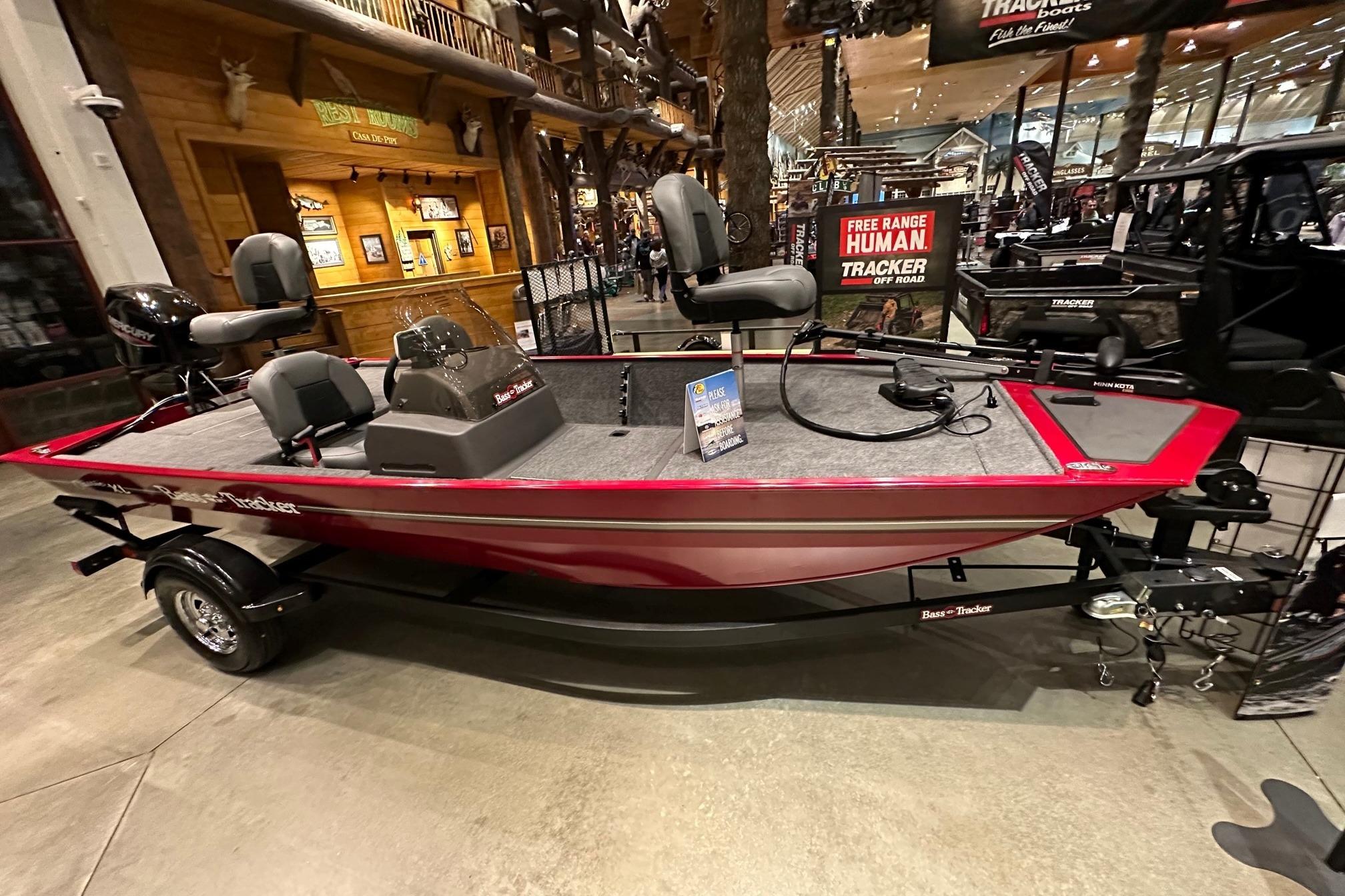 2026 Tracker Bass Tracker Classic XL boat displayed indoors, featuring red exterior and seating.