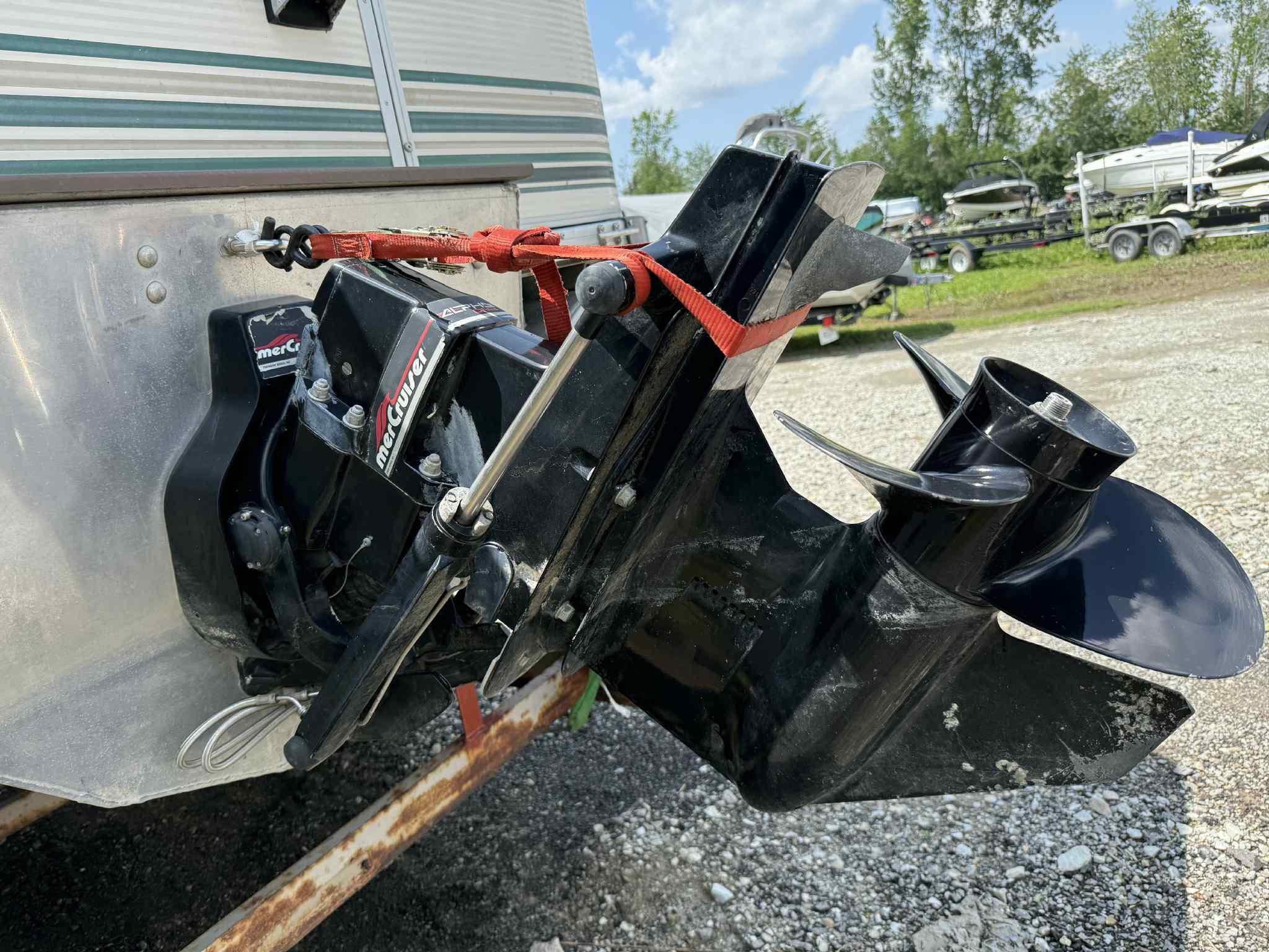 1999 Smoker Craft 8526 Pleasure Isle I/O boat engine with MerCruiser outdrive, parked outdoors.