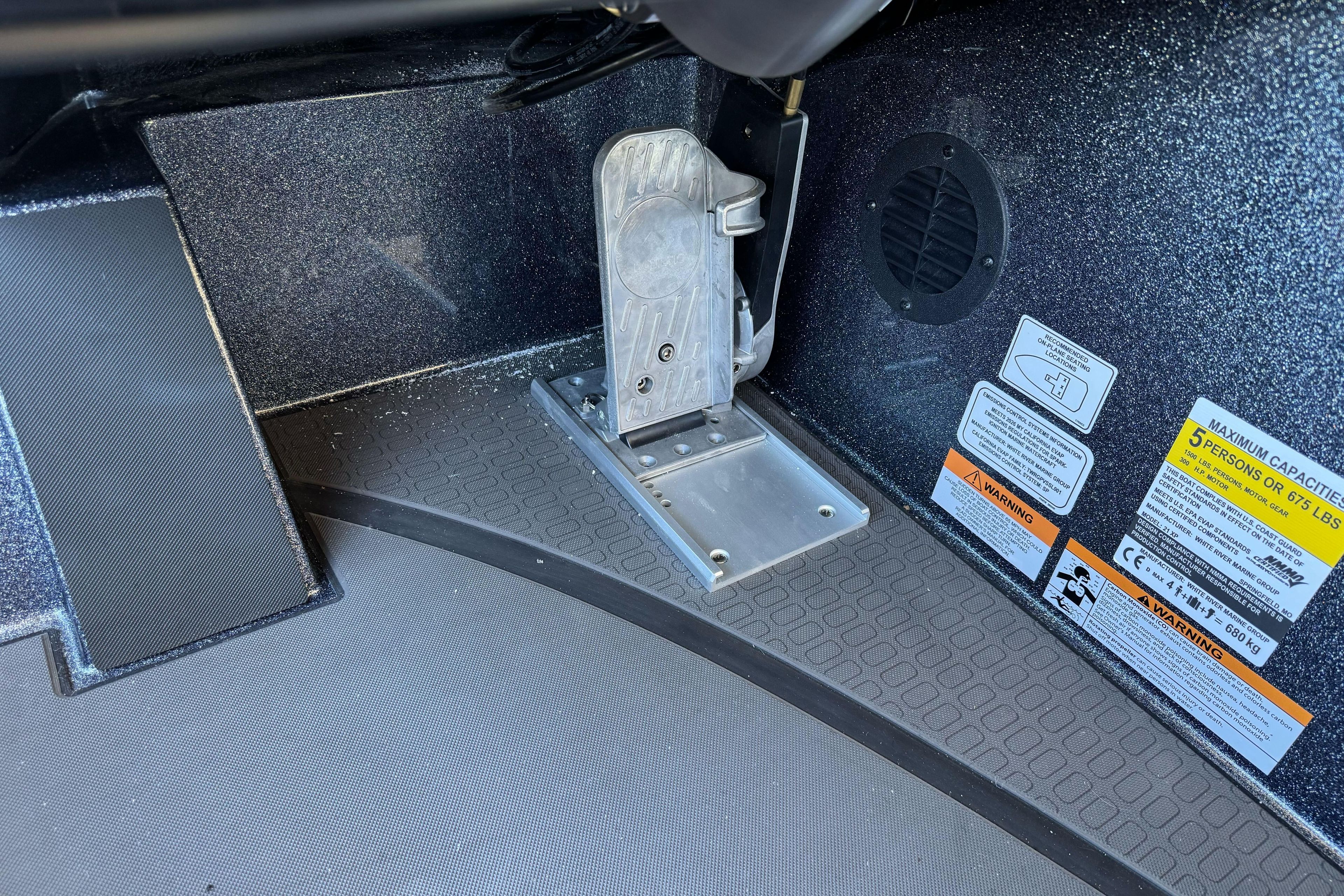 Interior view of 2026 Triton 21XP Patriot boat with foot pedal and safety labels.