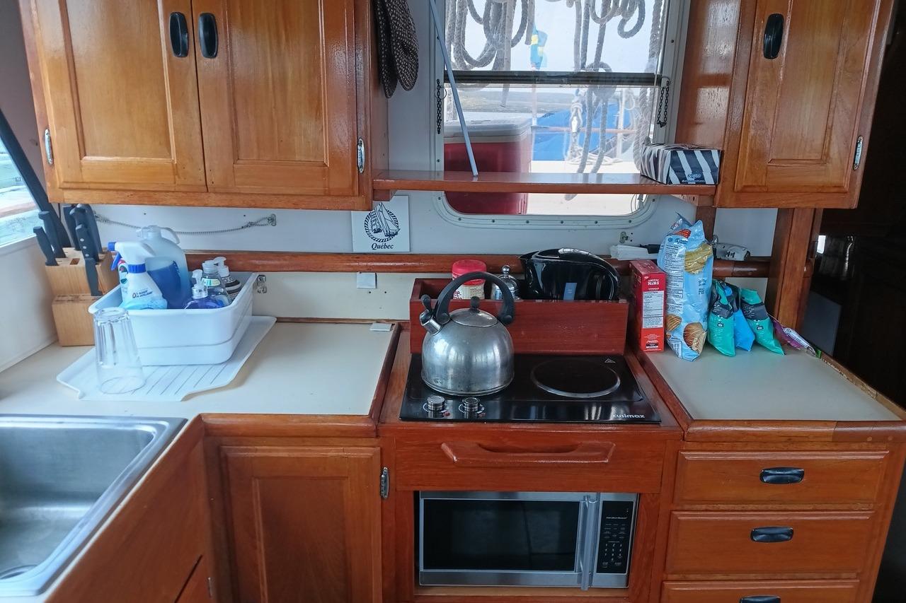 1974 DeFever 40 Passage Maker Trawler Yacht kitchen with wooden cabinets and modern appliances.