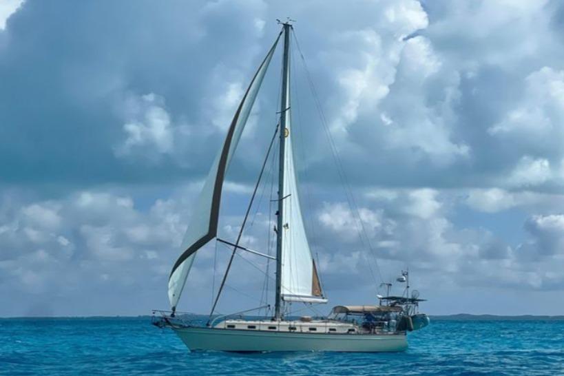 Sailing yacht Island Packet 420 (2000) on turquoise sea under cloudy sky.
