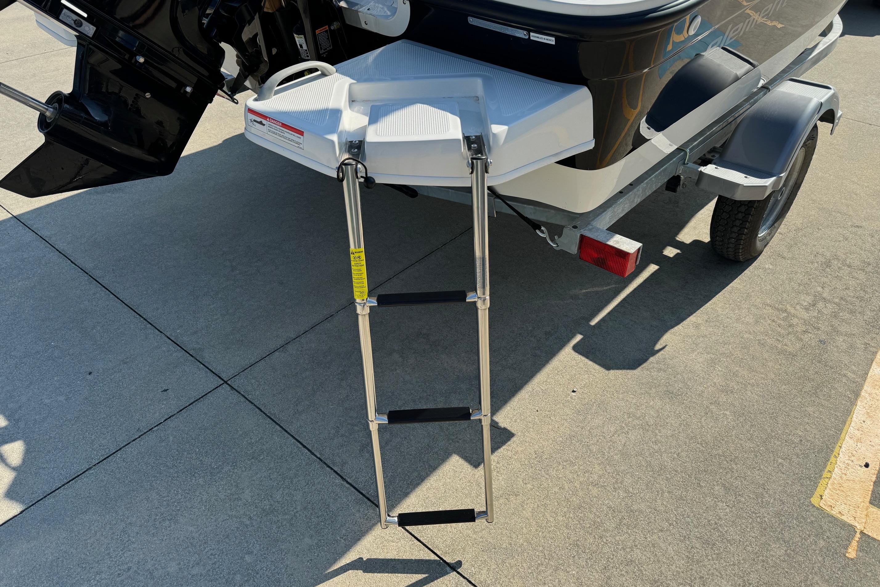 2025 Bayliner Element E16 boat with extended swim ladder on trailer.
