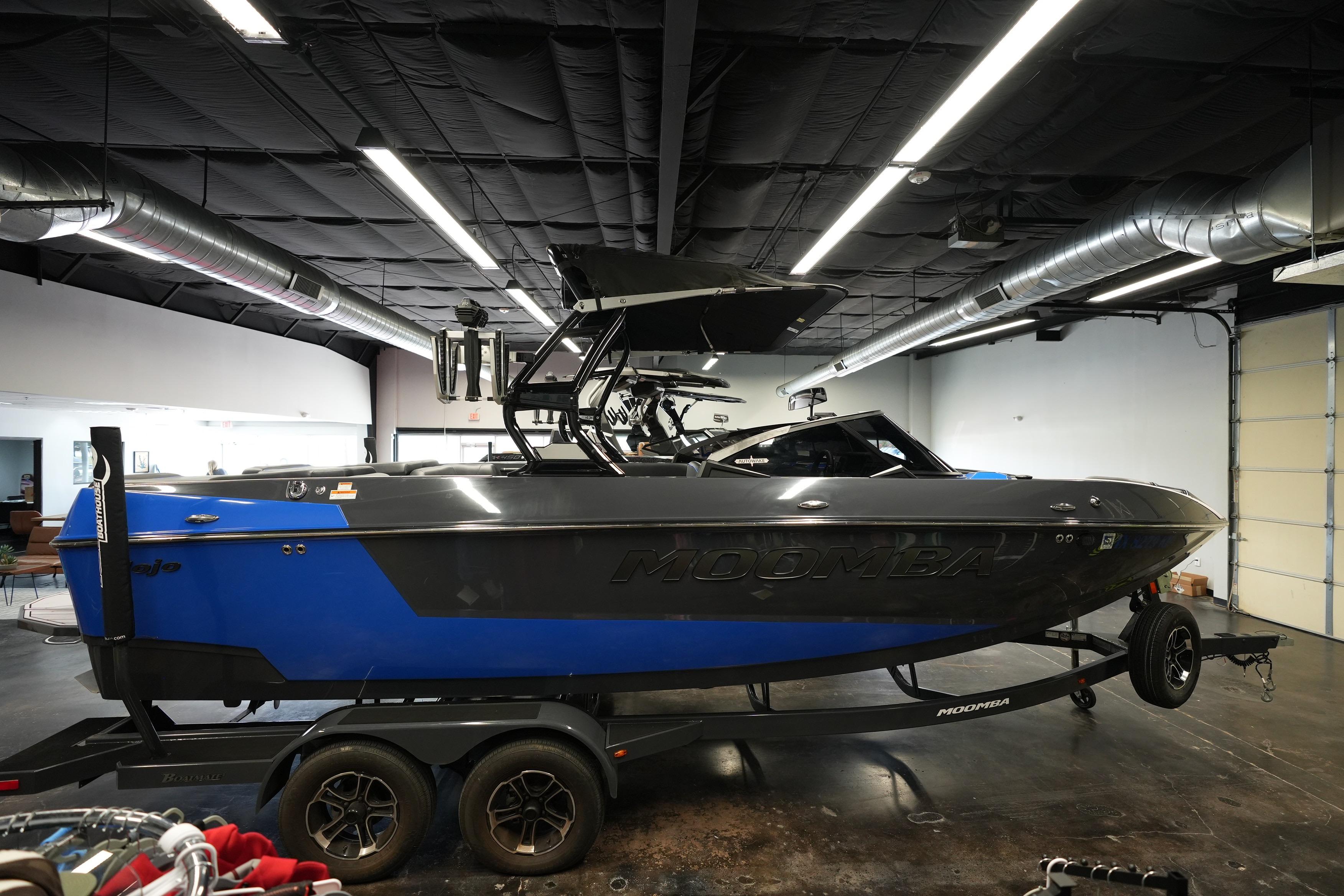 2023 Moomba Mojo boat in showroom, featuring sleek design and vibrant blue accents.