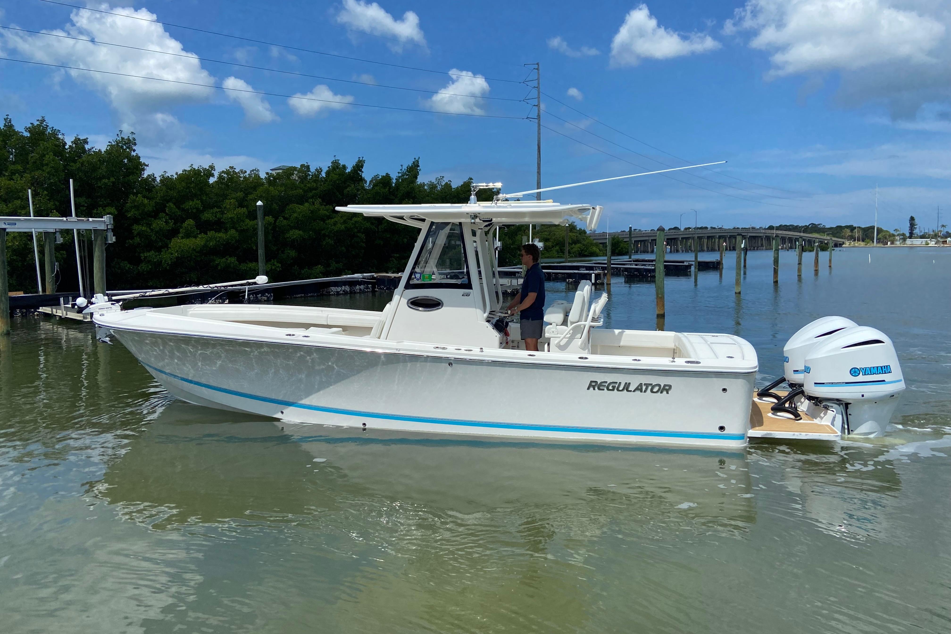 2021 Regulator 28 boat with Yamaha engines on calm water under blue sky.