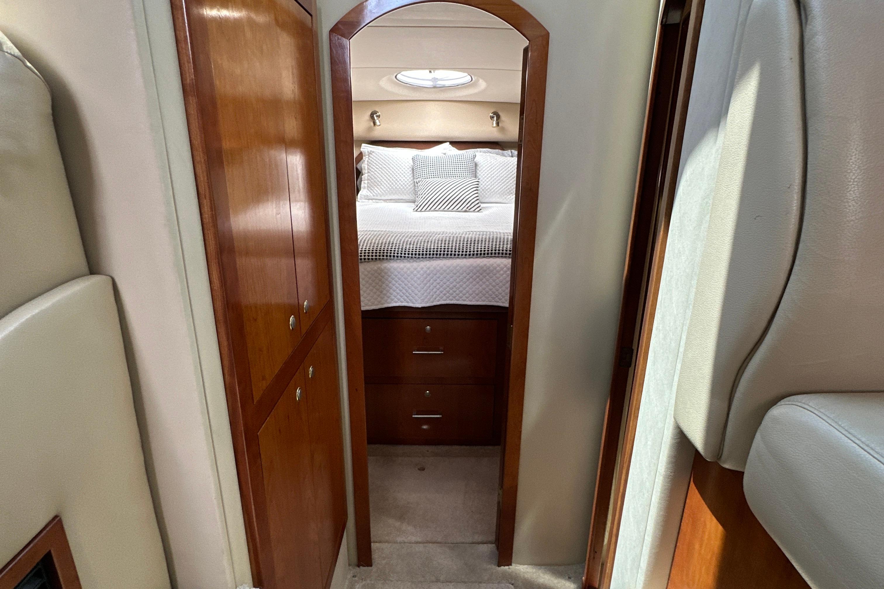 2004 Cruisers Yachts 405 Express Motoryacht interior with cozy bedroom and wooden cabinetry.