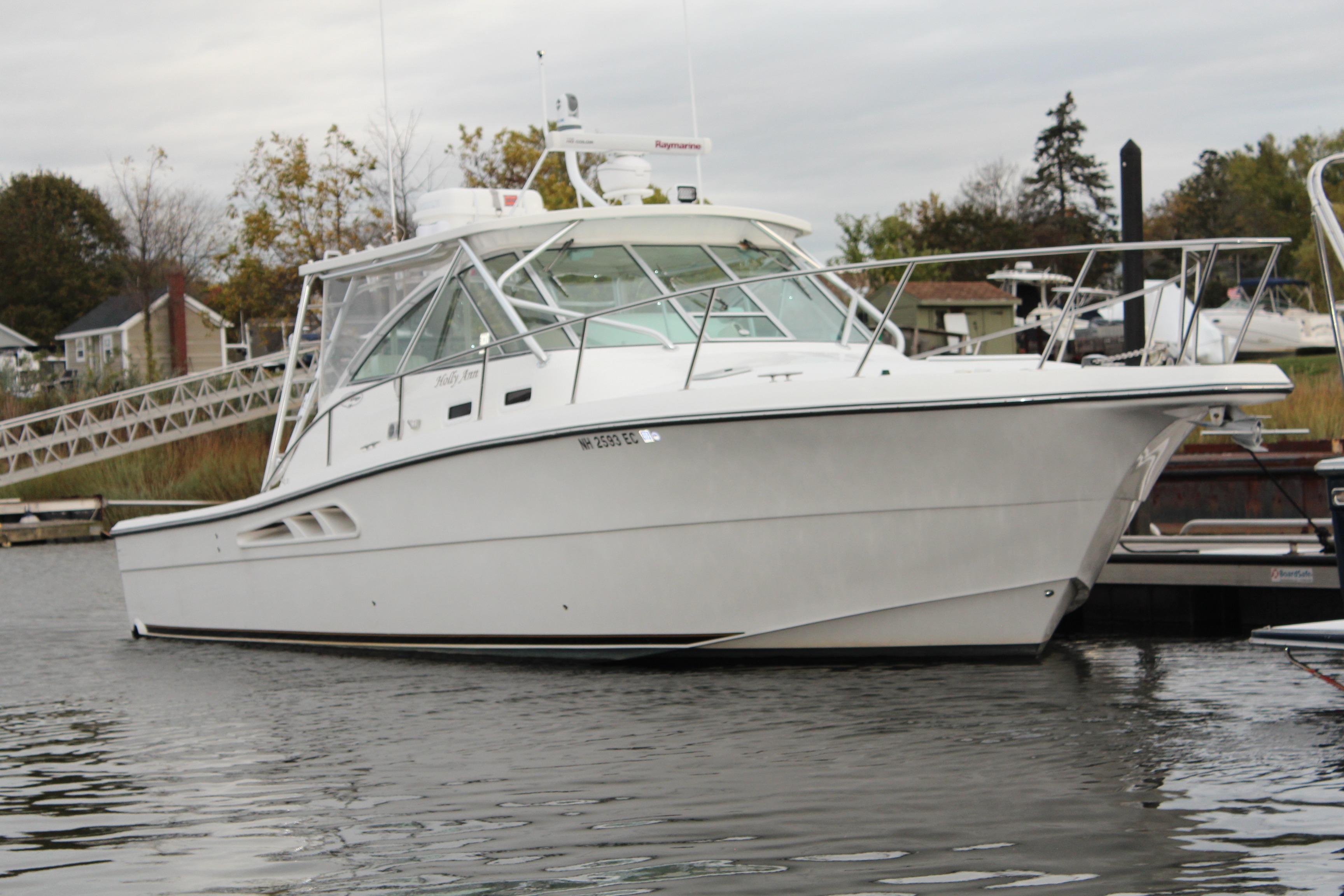 2005 Rampage 38 Express boat docked in a marina, side view.