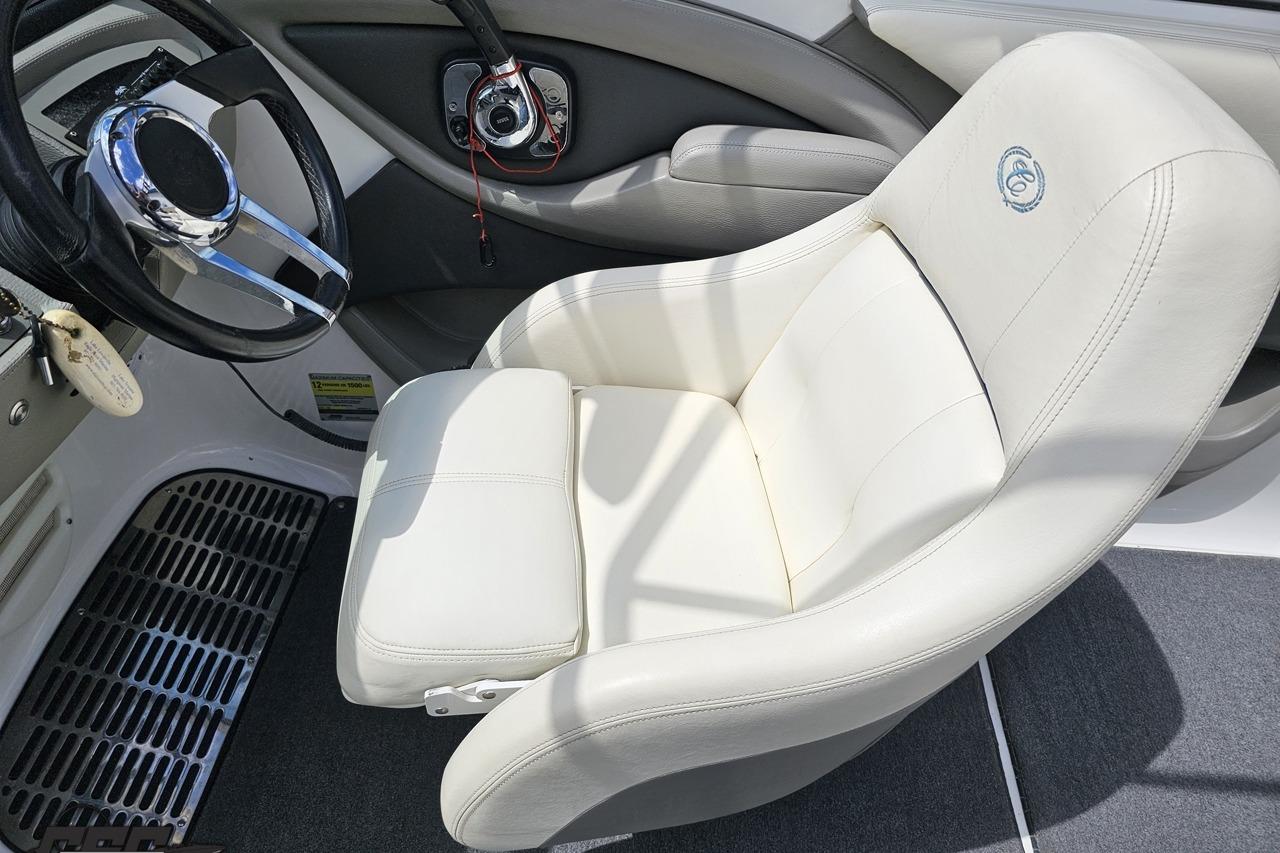 2010 Cobalt 232 WSS boat interior with white captain's chair and steering wheel.
