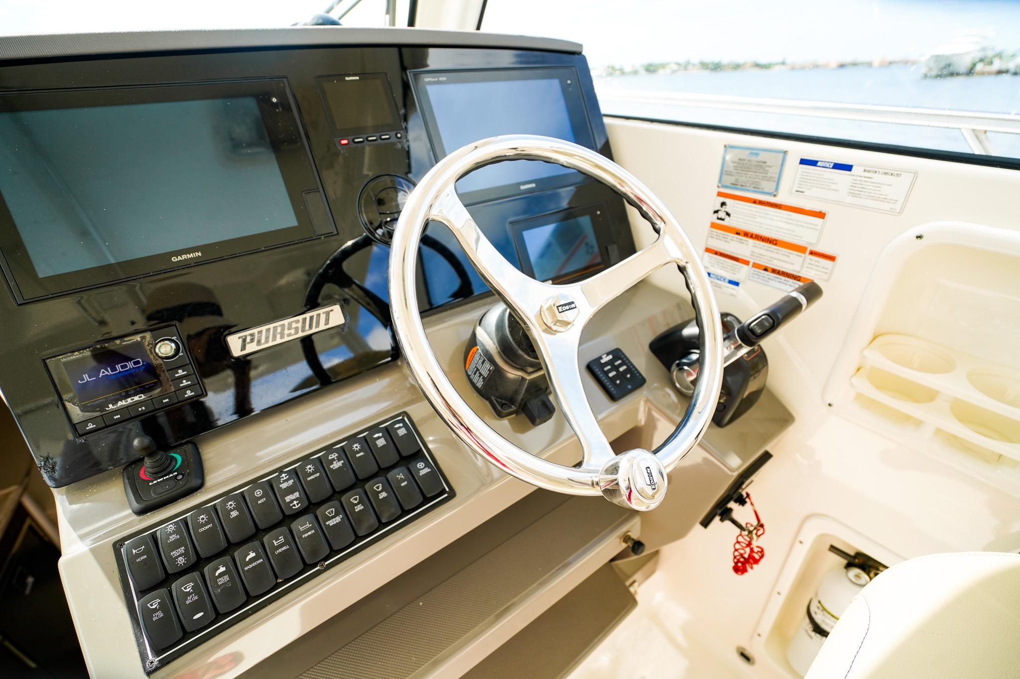 Helm of 2020 Pursuit OS 325 Offshore boat with modern controls and navigation displays.