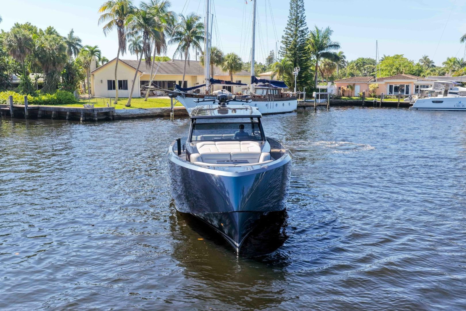 2022 Vanquish Yachts VQ45 cruising on a sunny day near waterfront homes.