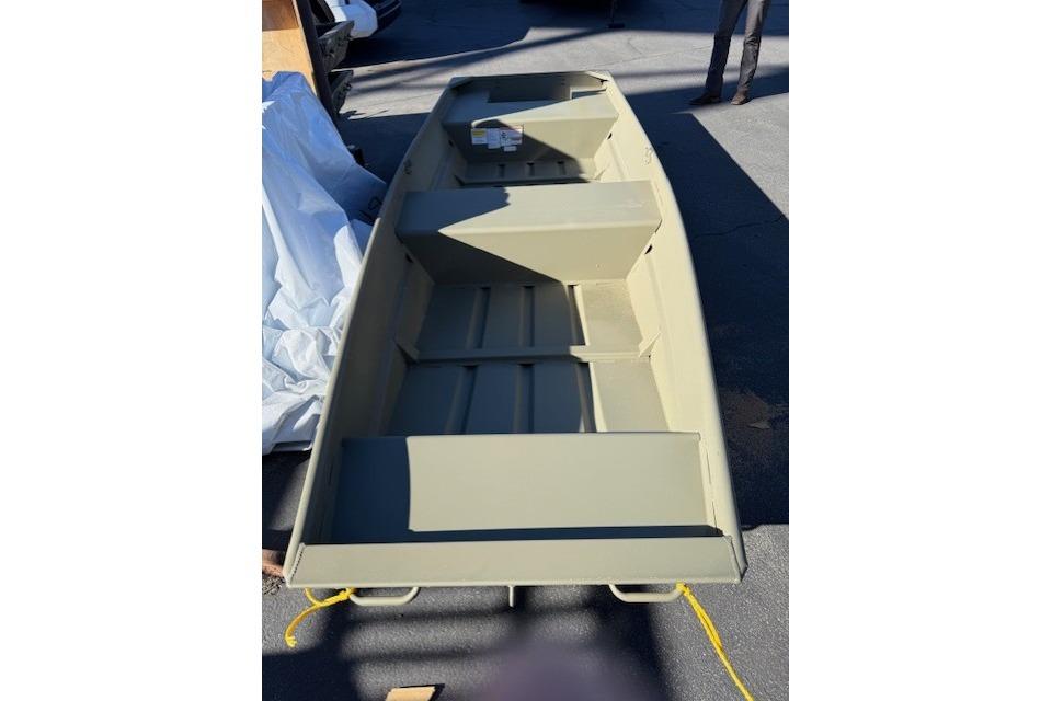 2026 Tracker Grizzly 14 Jon boat, beige, parked outdoors on pavement.