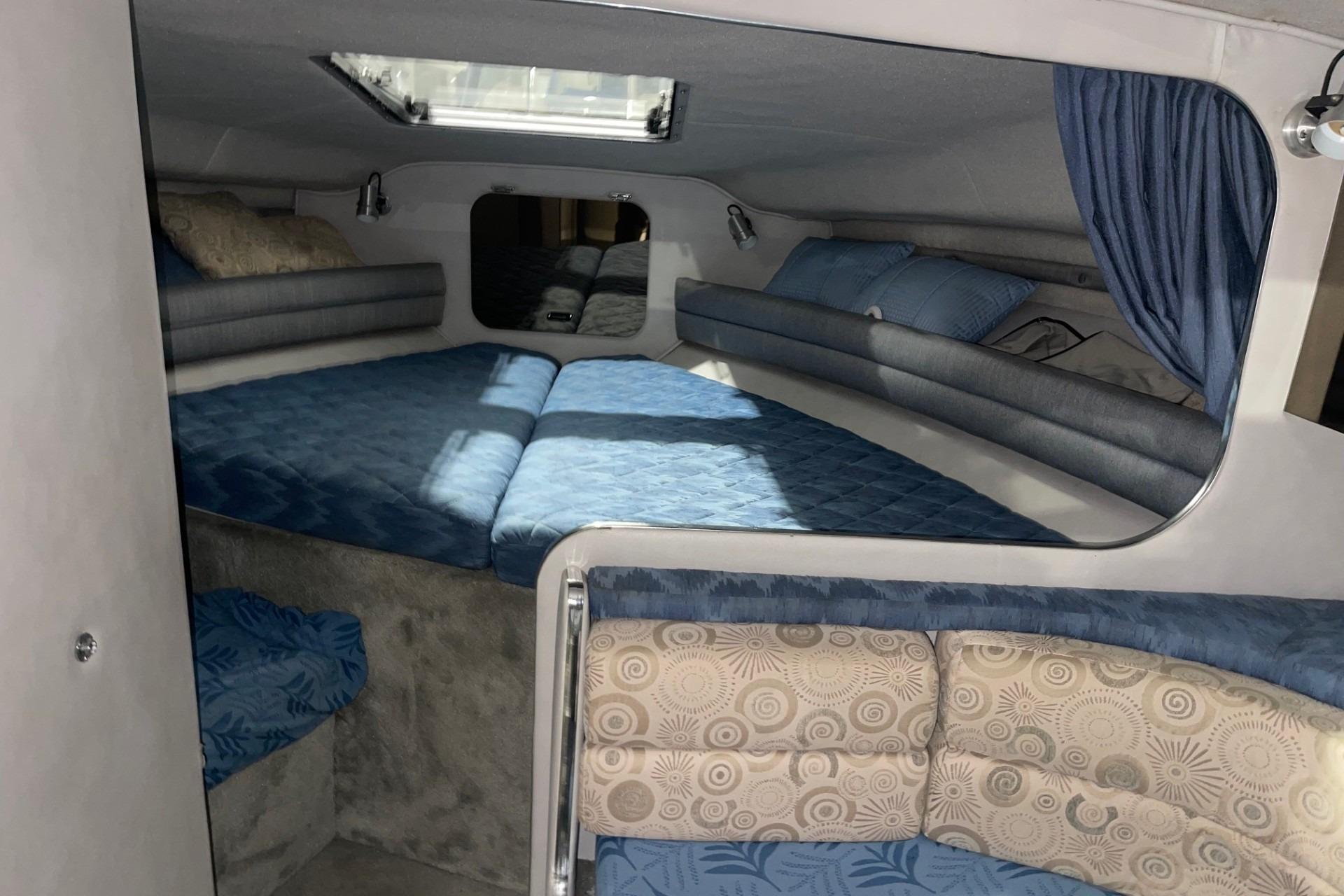 1992 Chaparral Signature 30 cabin interior with blue bedding and cozy seating area.