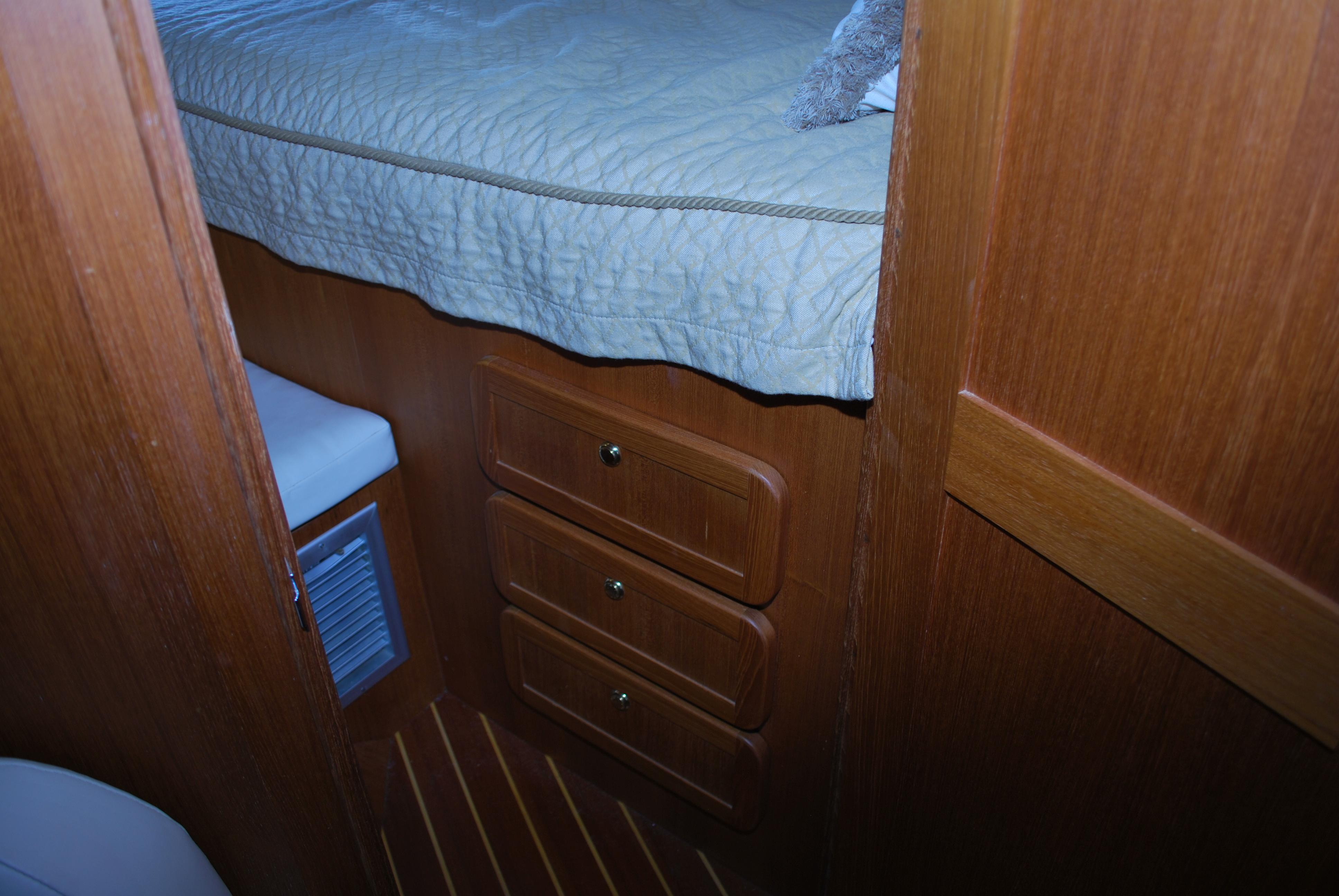 Interior cabin of 2005 Stamas 370 Express with wooden drawers and bed.