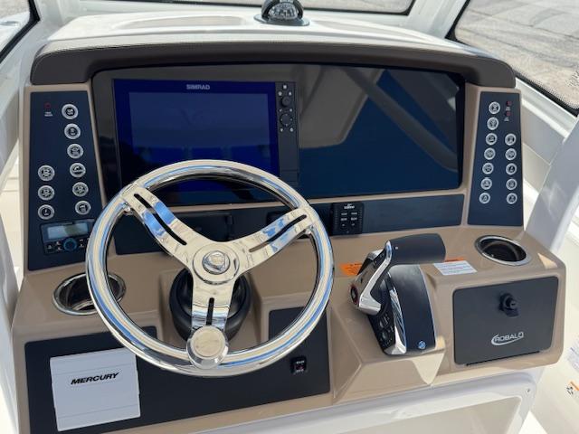 2025 Robalo 266 Cayman helm with steering wheel, controls, and navigation display.