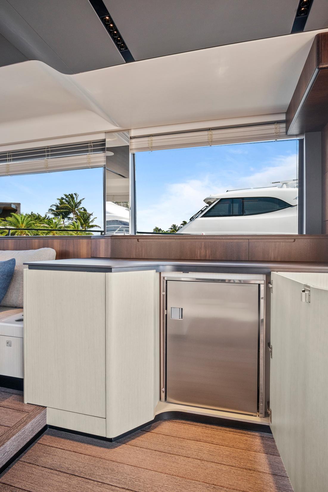 Luxurious interior of 2023 Astondoa AS5 yacht with modern cabinetry and scenic window view.