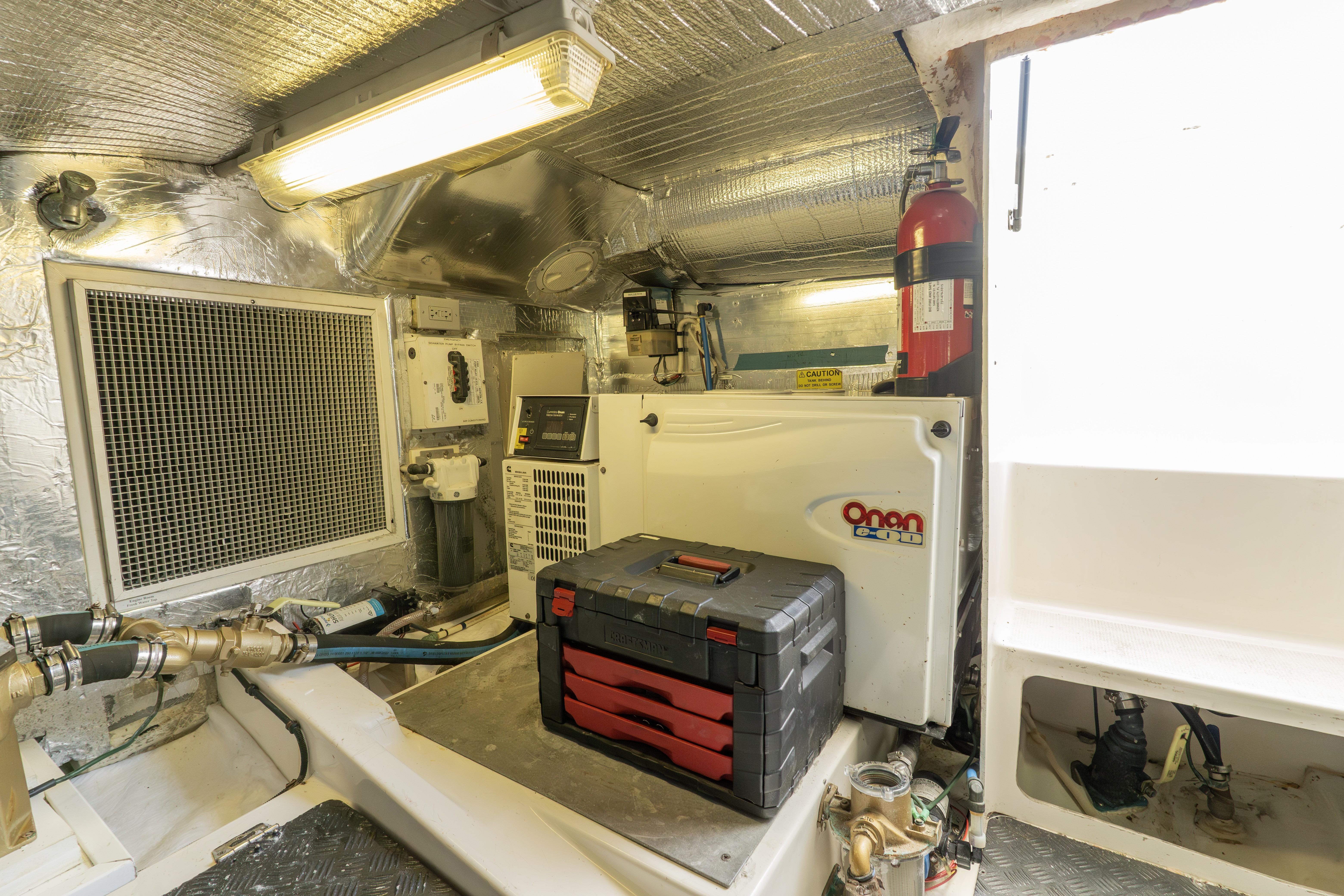 Engine room of 2008 Maritimo 52 yacht with Onan generator and toolbox.