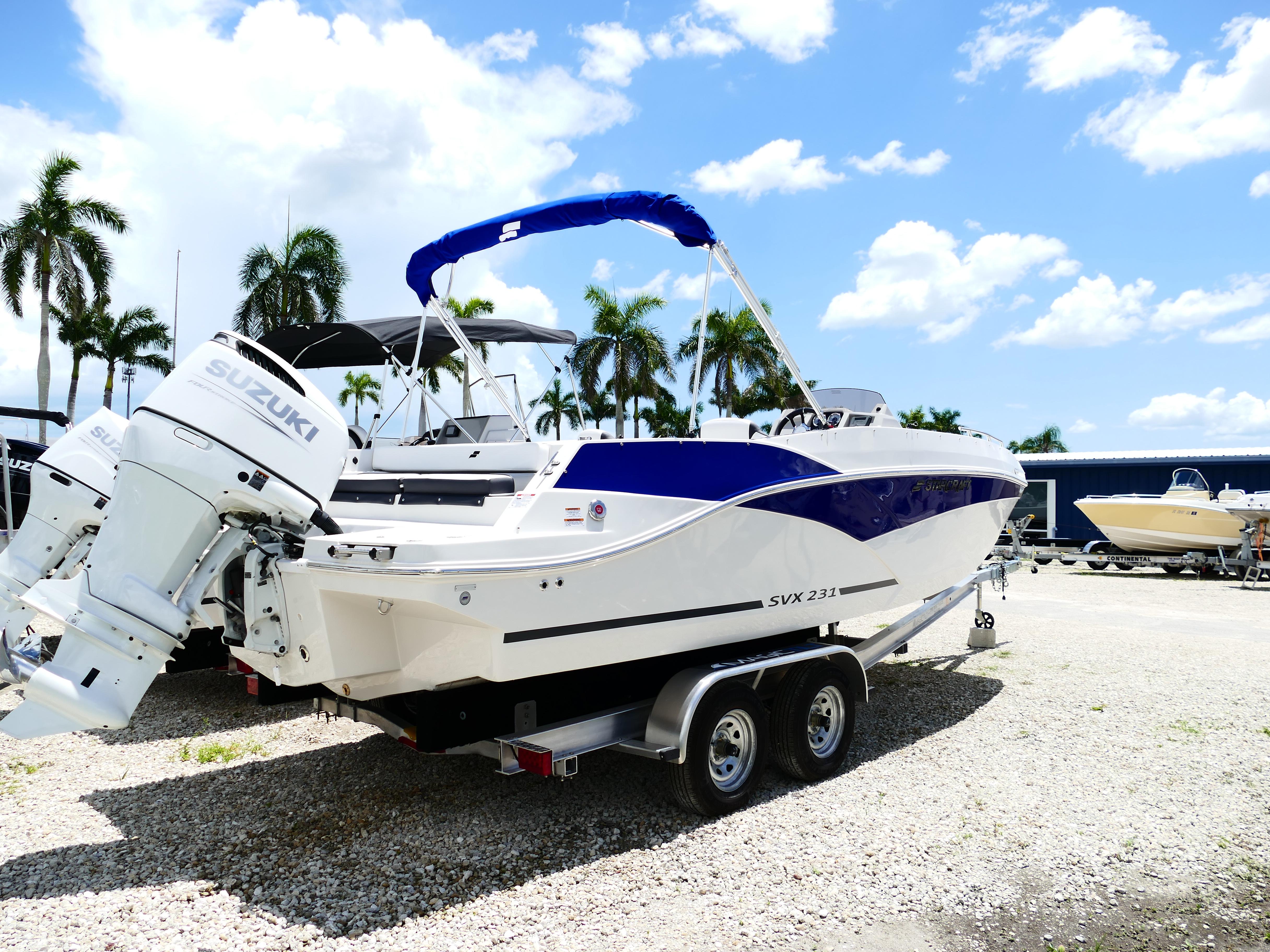2026 Starcraft SVX 231 OB DH boat with Suzuki engine on trailer, parked outdoors.