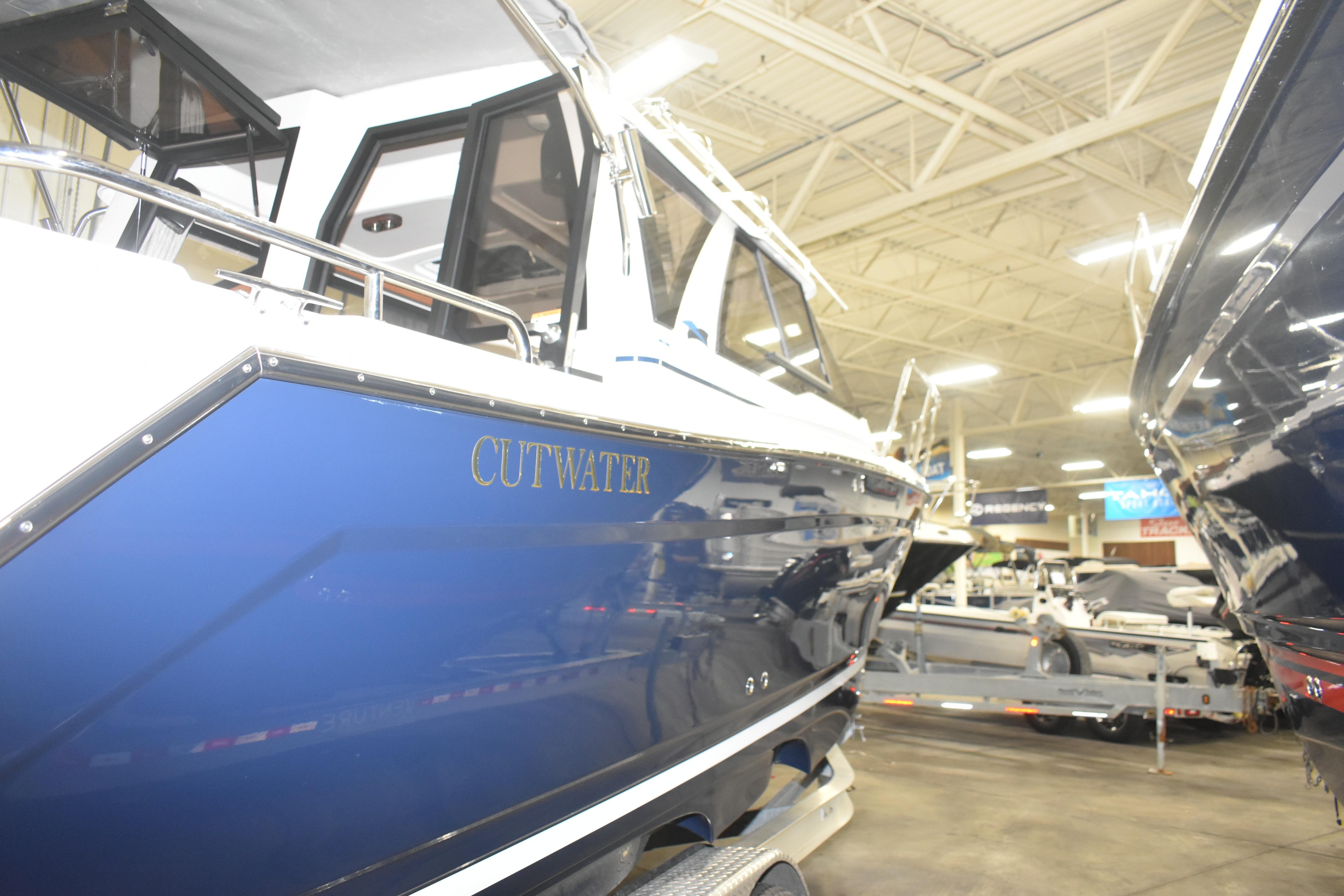 2026 Cutwater C-248 Coupe boat displayed indoors, showcasing sleek blue design.