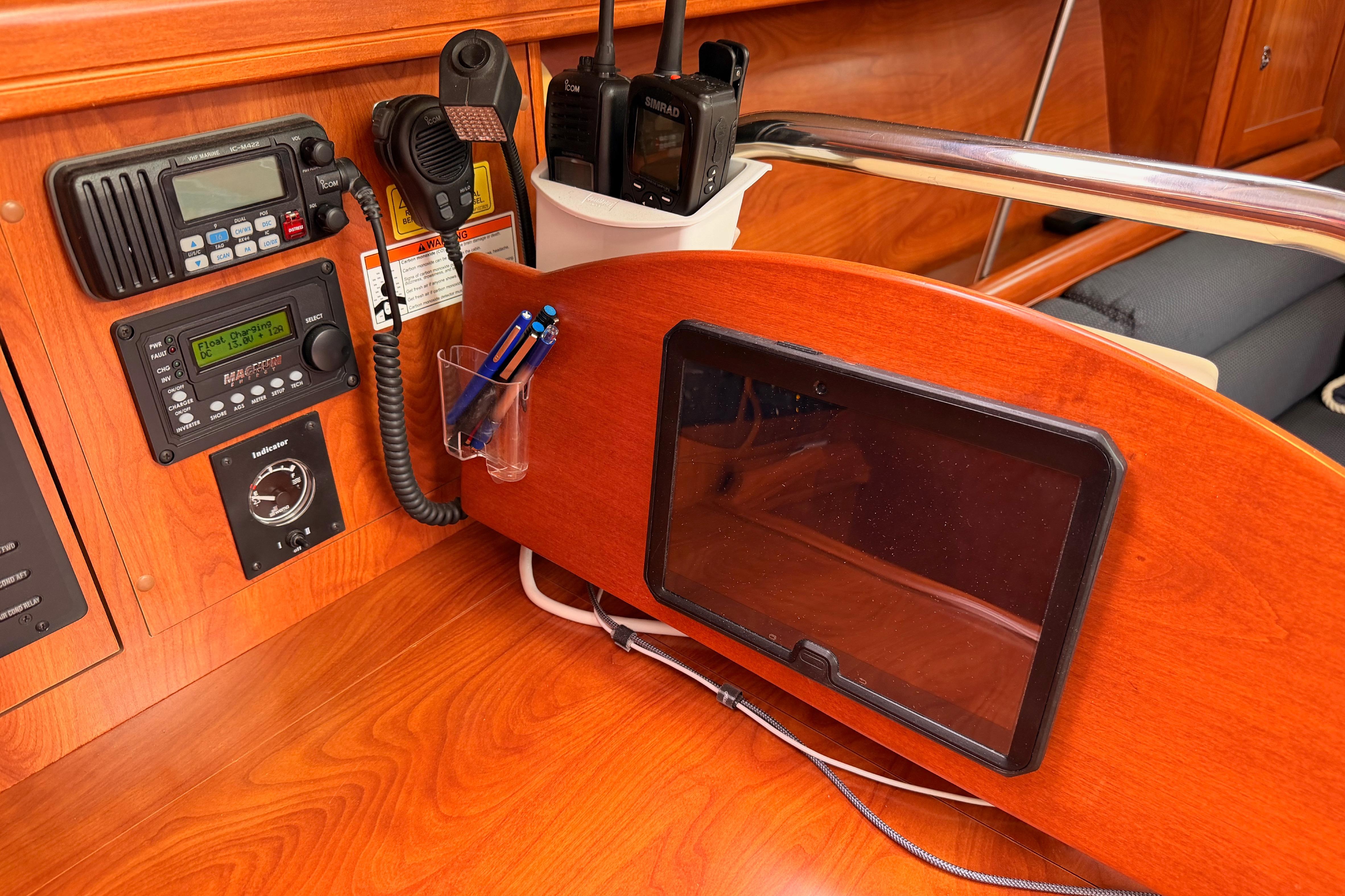 Navigation station on a 2009 Hunter 38 sailboat with communication equipment and tablet holder.