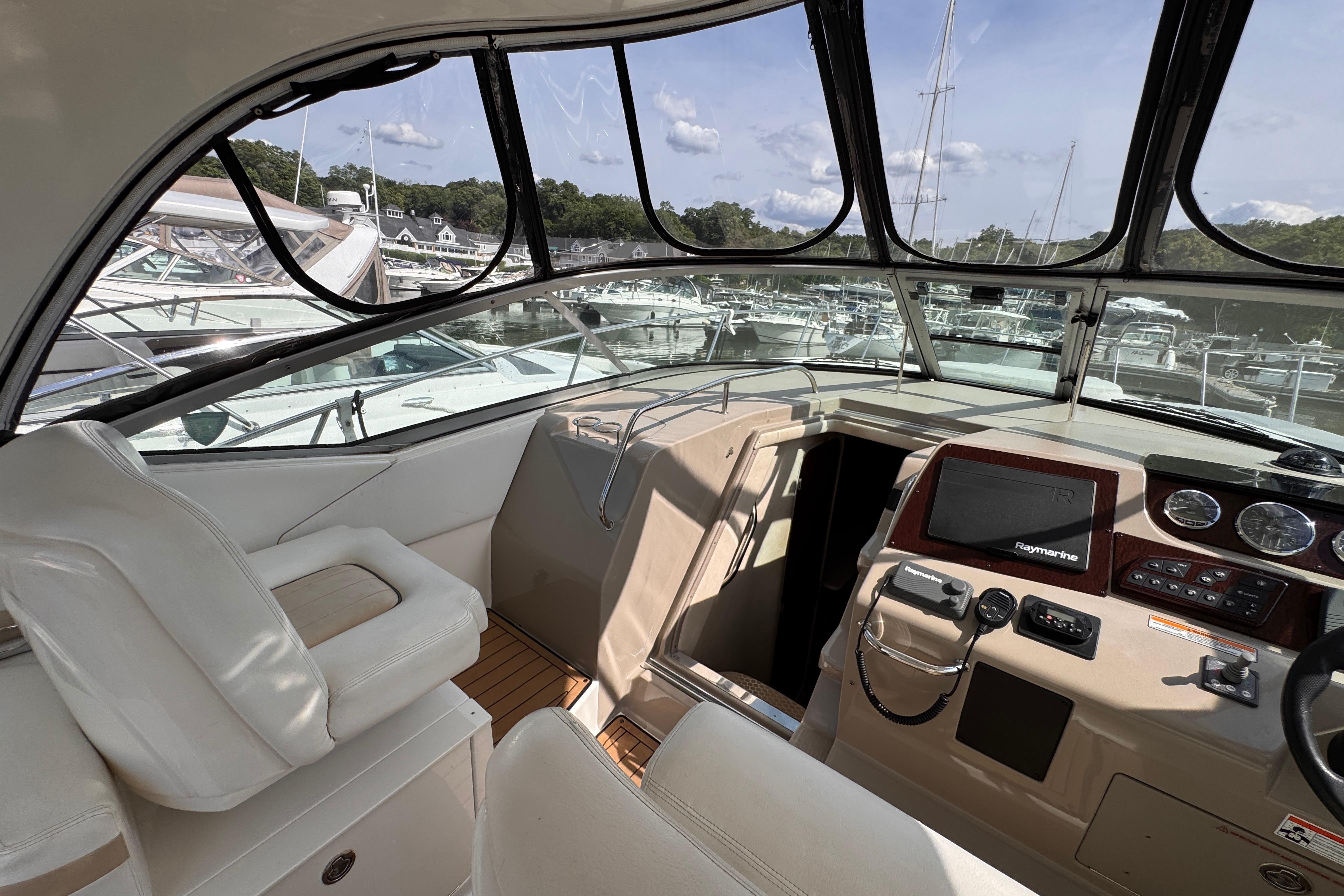 2008 Sea Ray Sundancer 350 cockpit with helm, navigation equipment, and marina view.