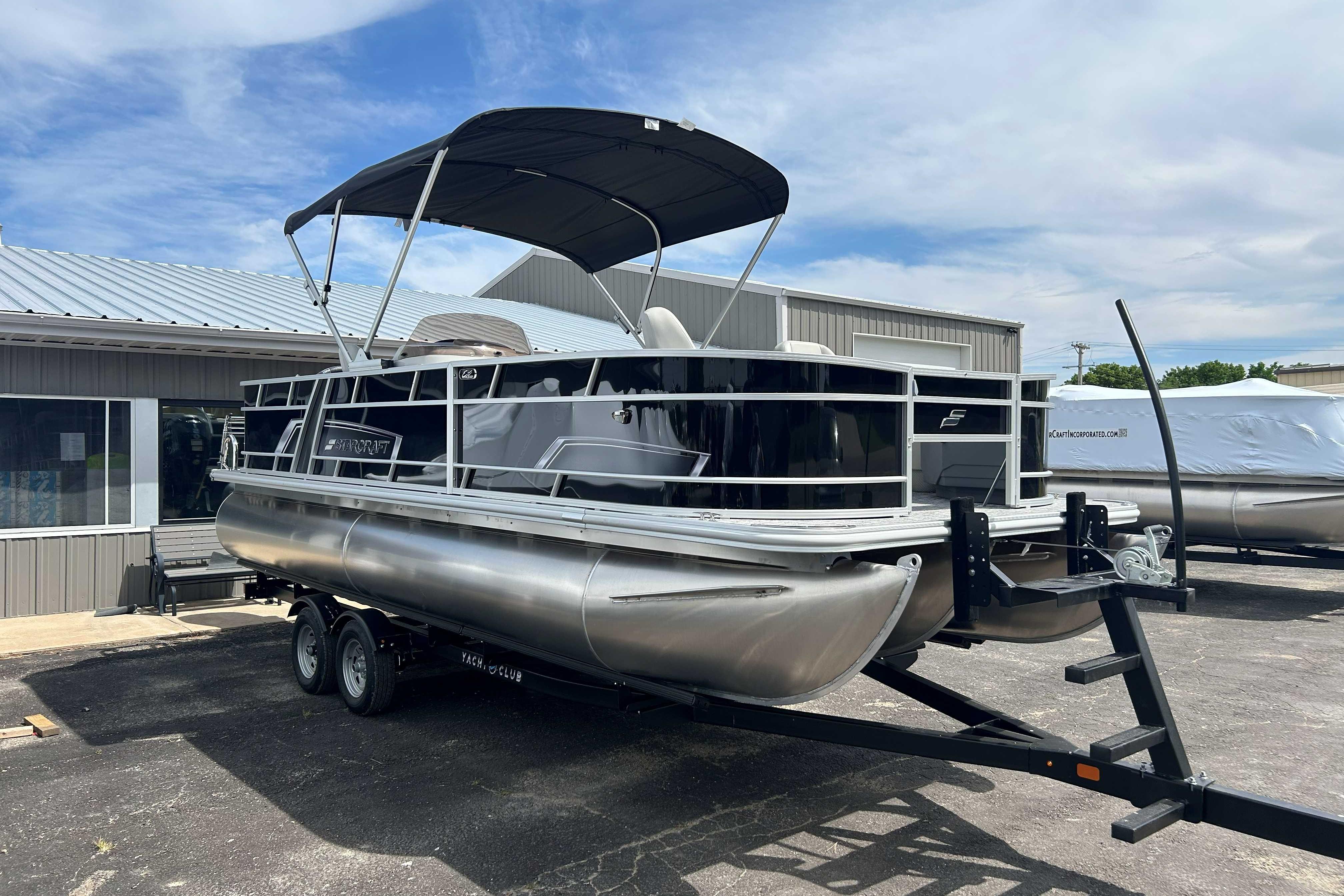 2026 Starcraft EX 22 FD pontoon boat on trailer, parked outside a building.