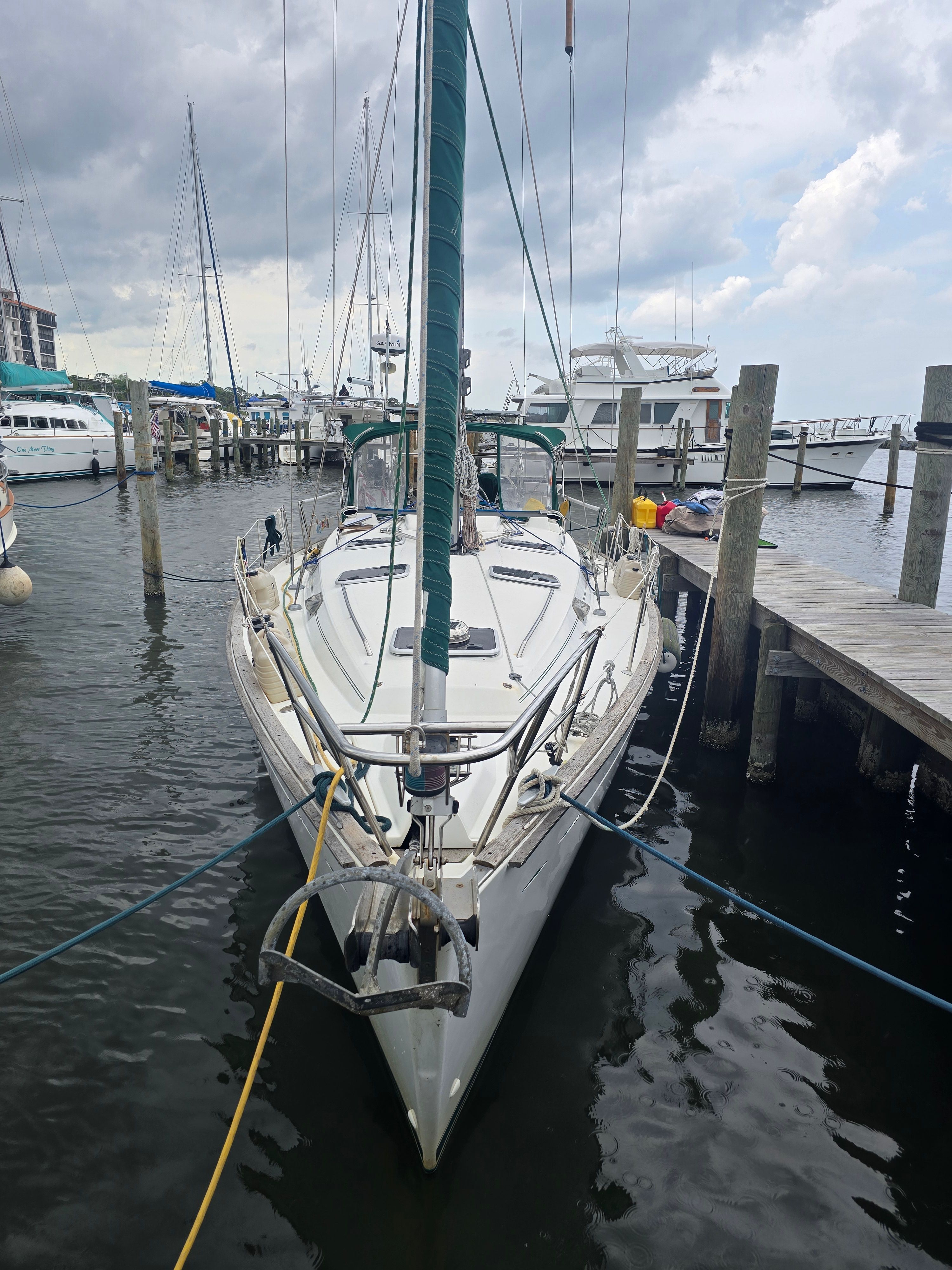 A 1998 Beneteau 411 sailboat docked at a pier, surrounded by other boats.
