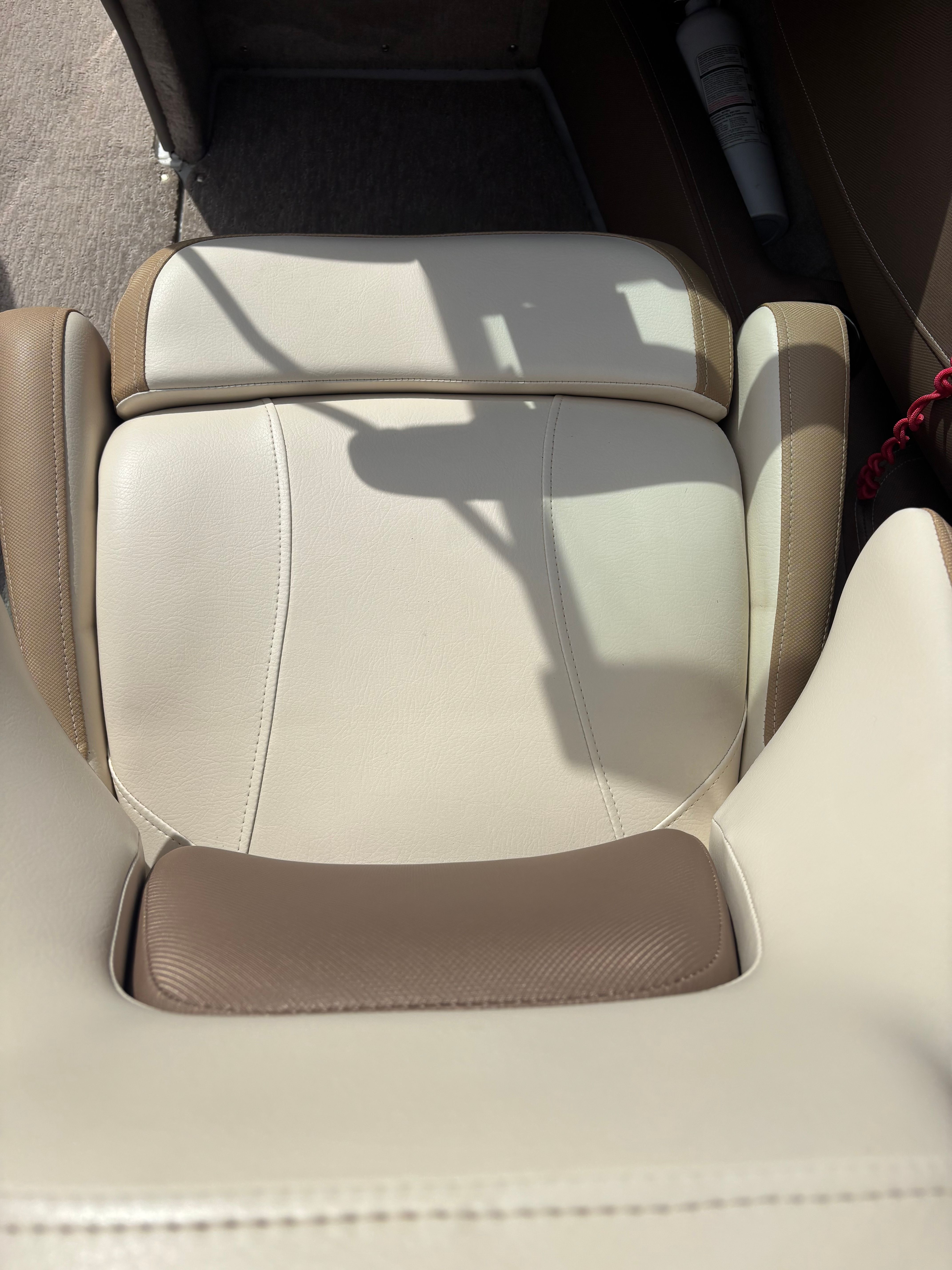 Close-up of a beige and brown boat seat with armrests.