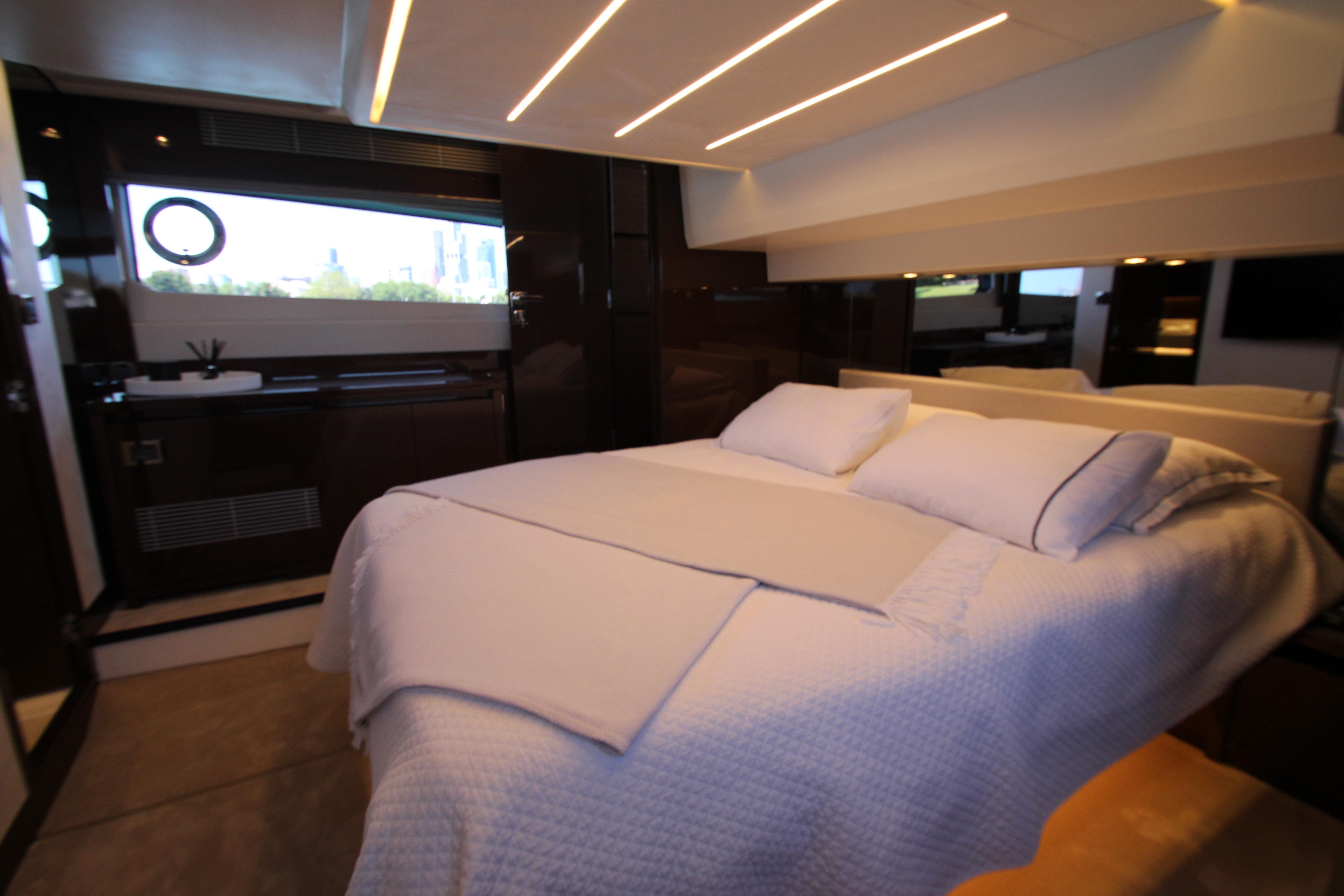 Luxurious bedroom interior of 2022 Prestige 520 yacht with modern lighting and elegant decor.
