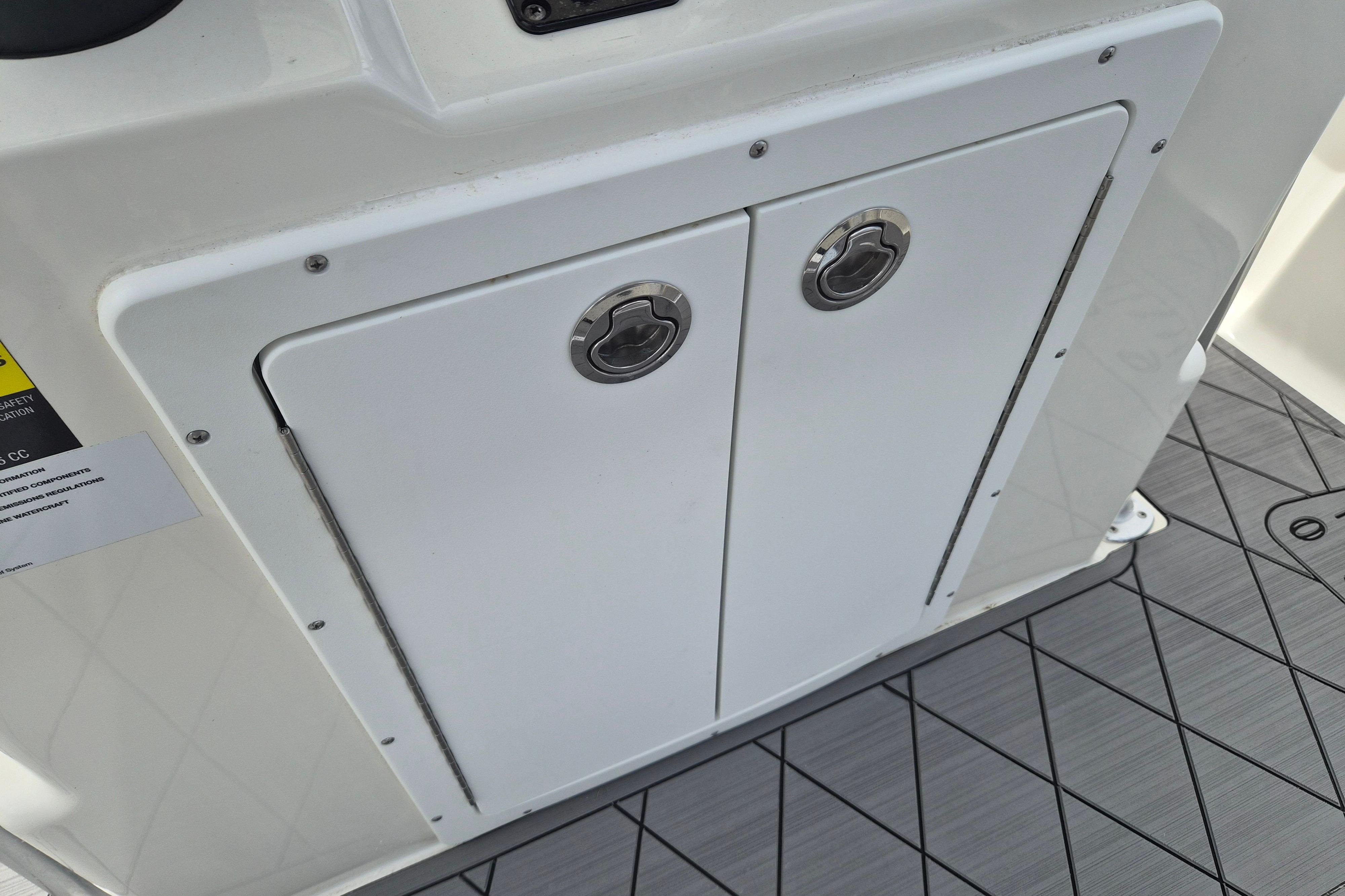 Storage compartment on 2026 Defiance Catalina 190 boat with dual handles and non-slip flooring.