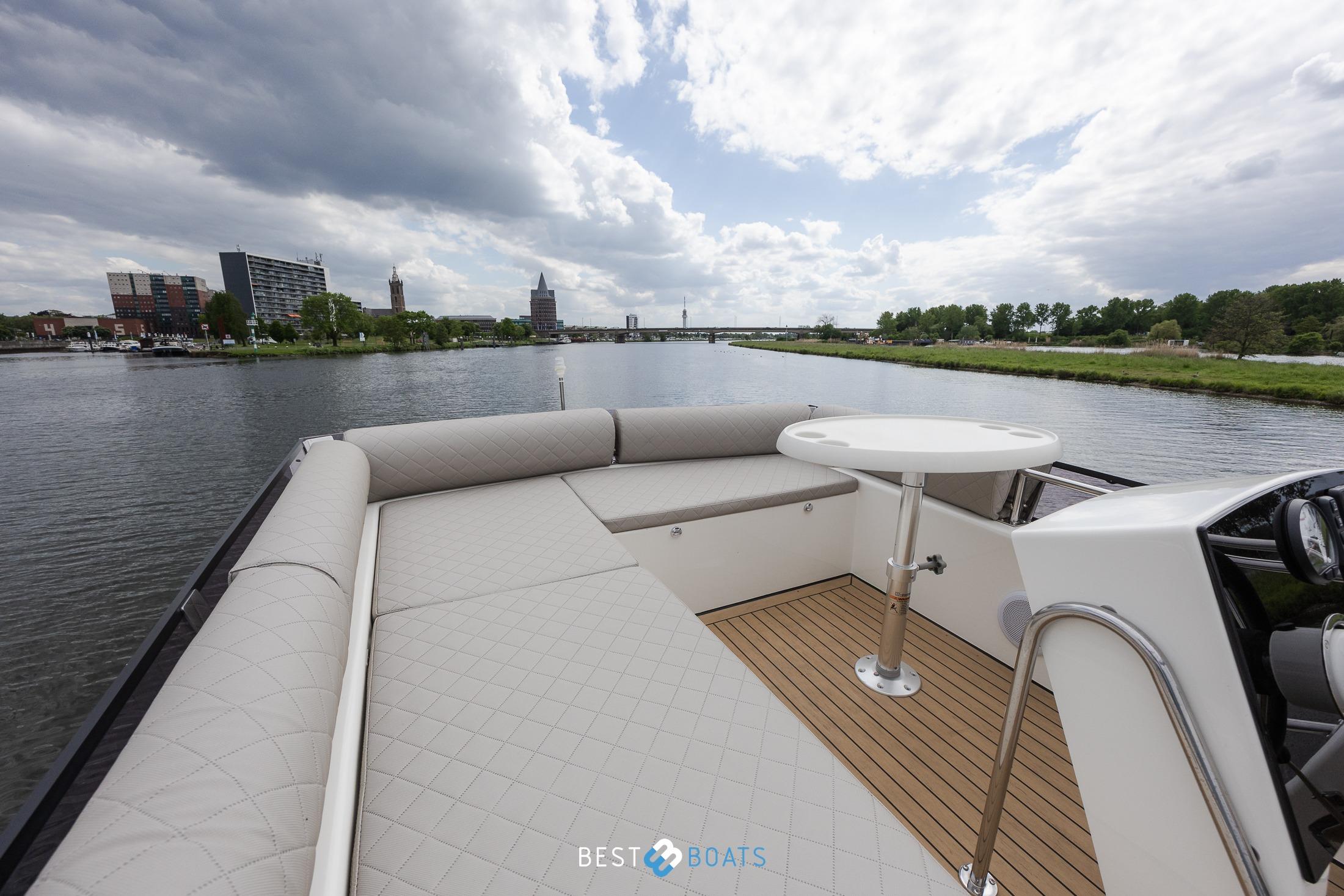 2023 Cobra Yachts Futura 36 Premium Fly on a scenic river with modern buildings.