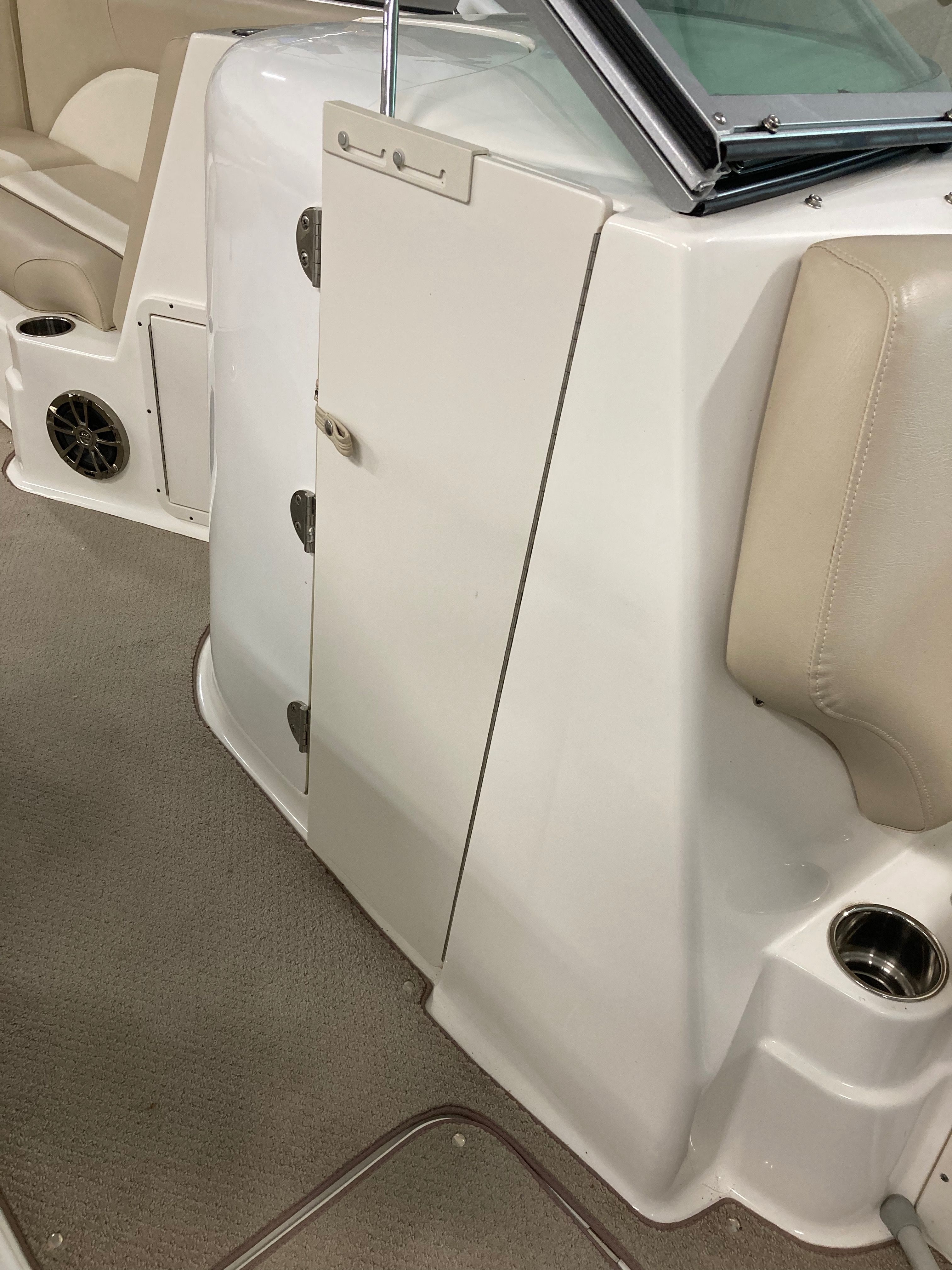 Interior of a 2016 Custom 223 DC boat with beige seating and carpeted flooring.