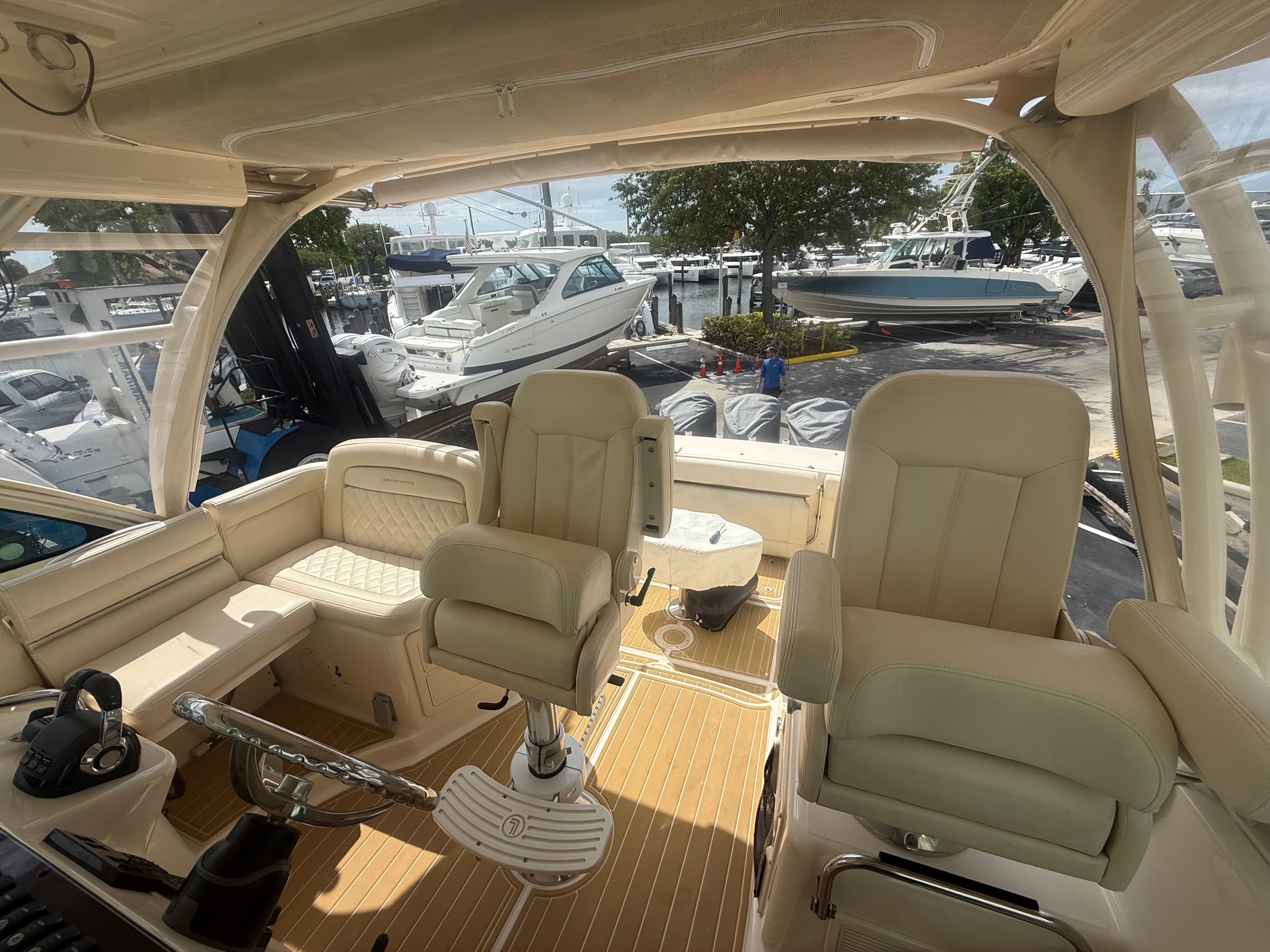 The image shows the cockpit of a 2018 Grady-White Express 370 with beige seats and a steering wheel.