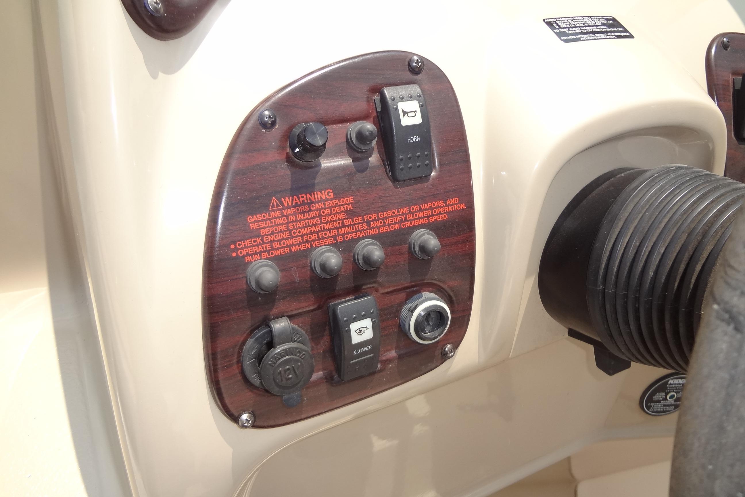 Control panel of 2000 Chaparral Signature 260 boat with warning labels and switches.