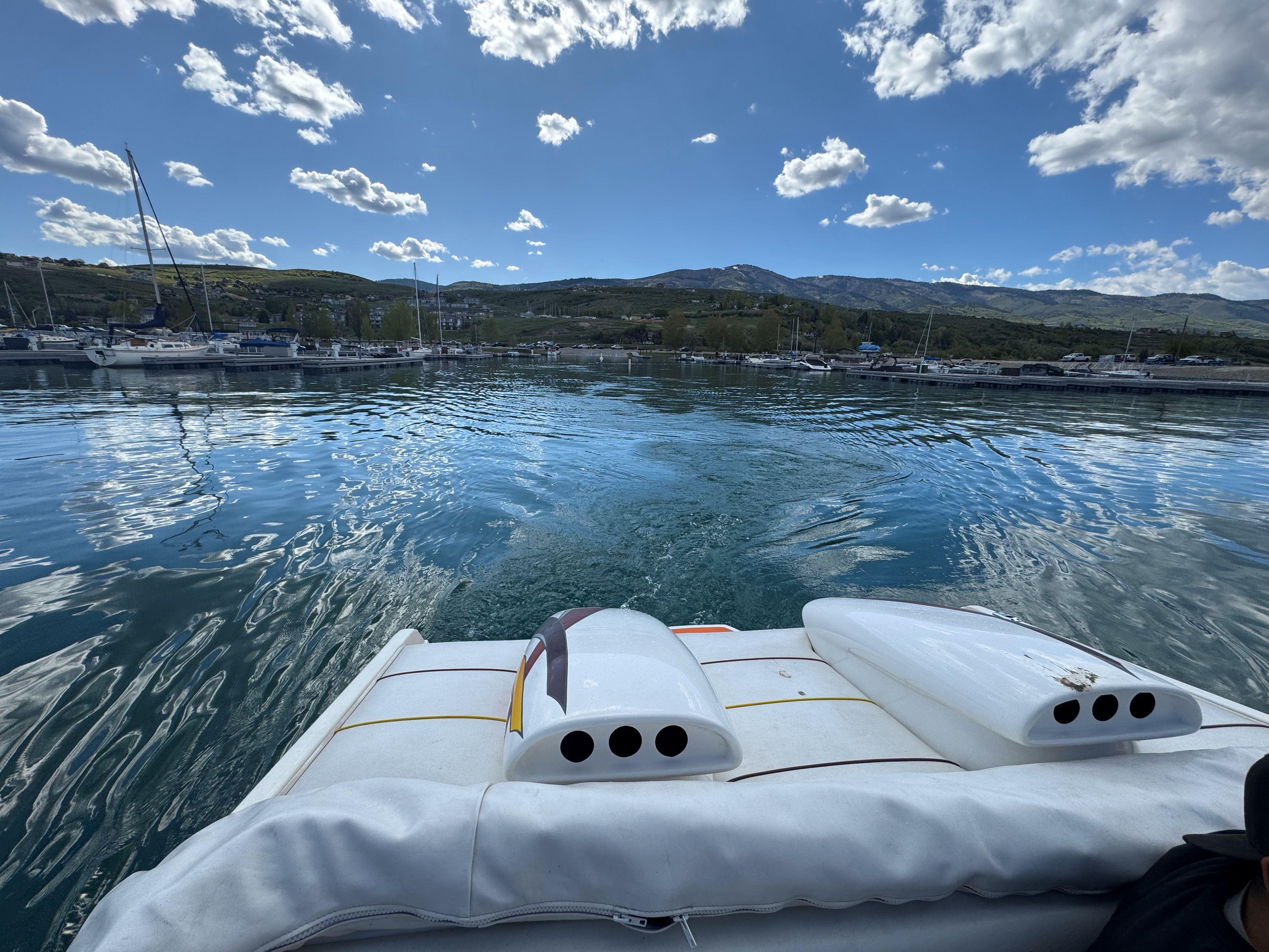 Boat on calm water with scenic mountain backdrop, Advantage Victory 2002 model.