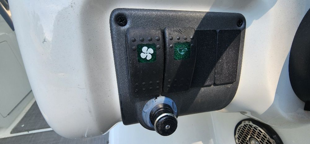 Close-up of a control panel with switches and a knob on a boat.