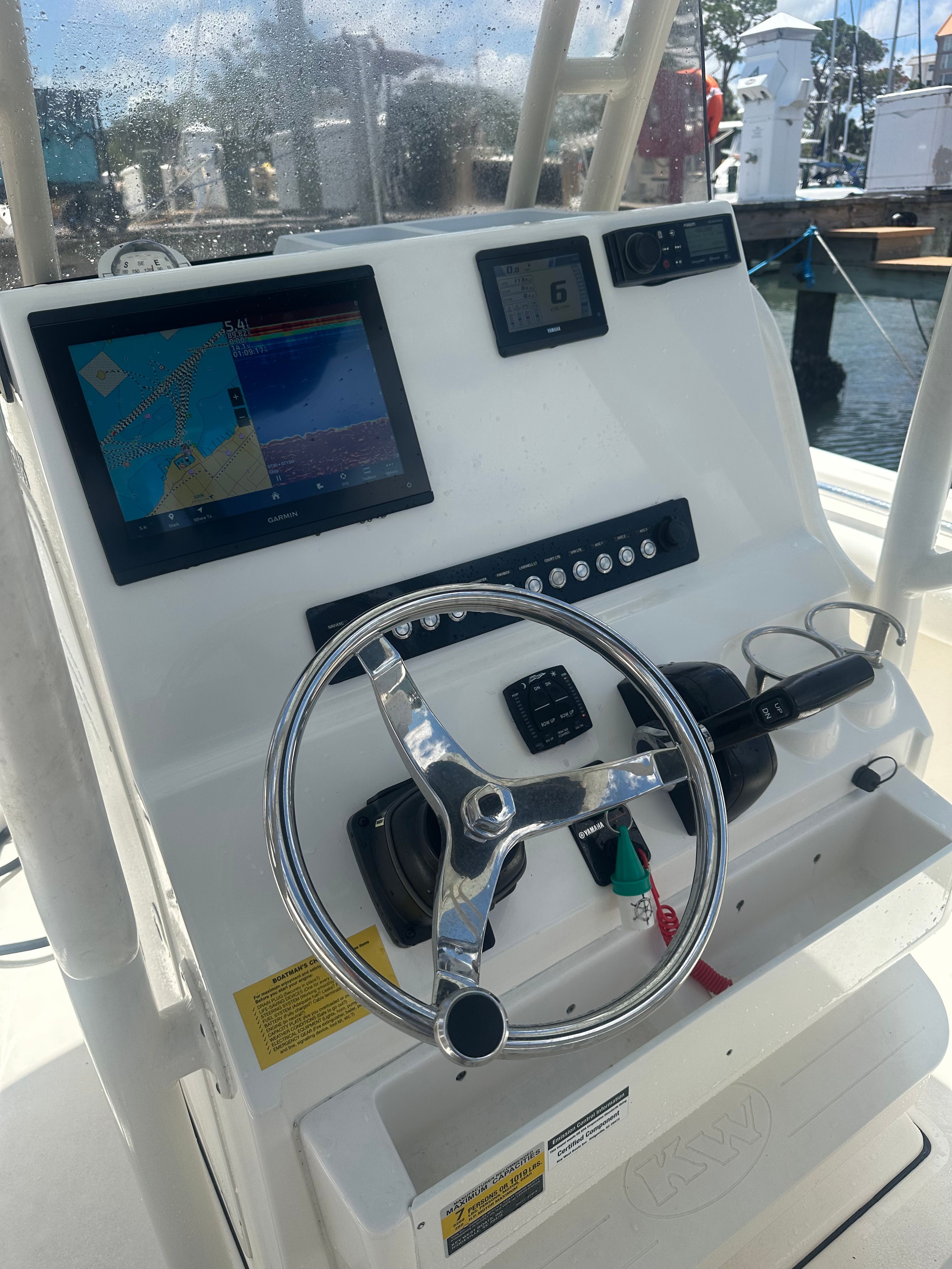 The cockpit of a Key West 219 FS boat with steering and navigation system.