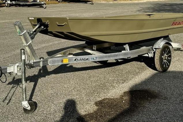 2026 Tracker Grizzly 14 Jon boat on Magic Tilt trailer in parking lot.