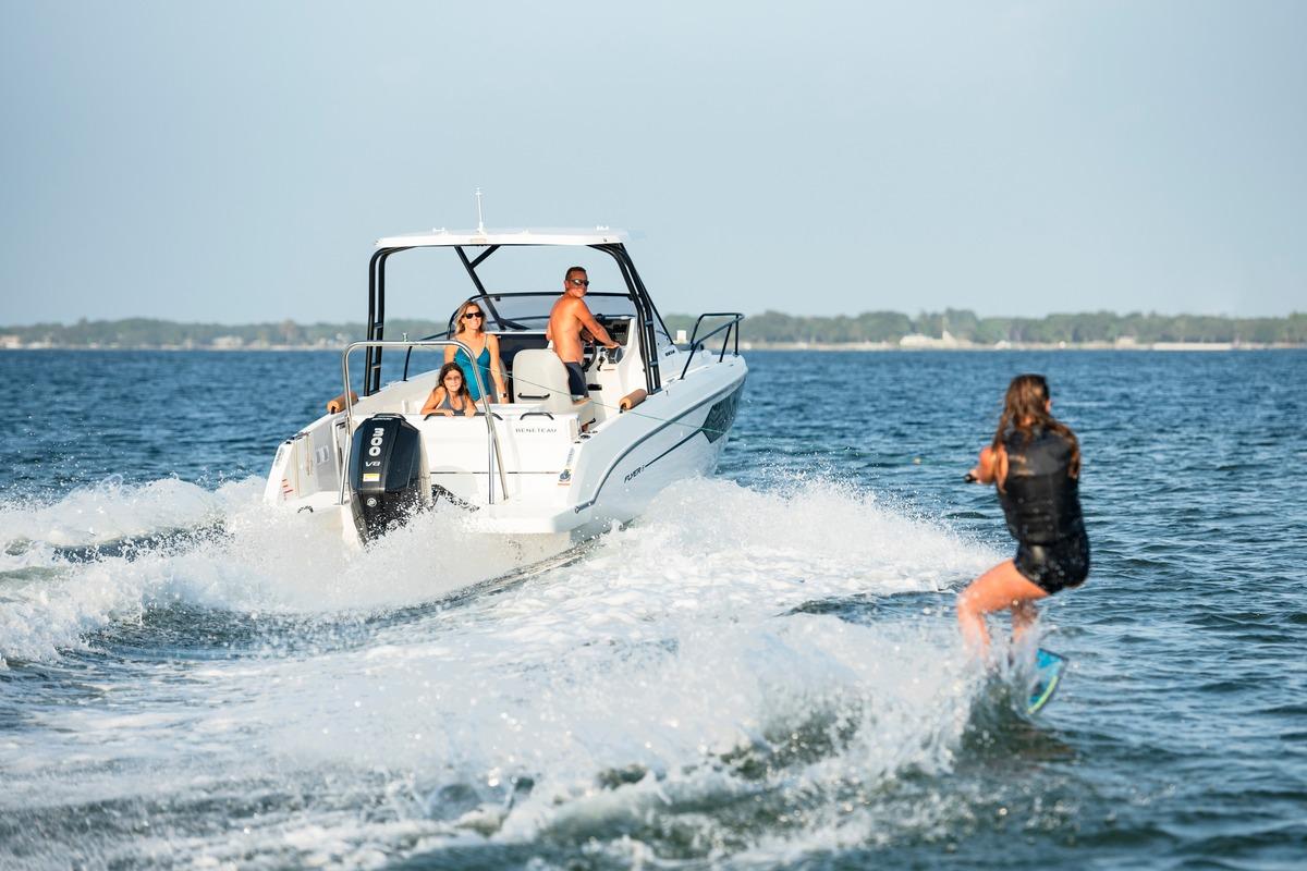 2026 Beneteau Flyer 8 SUNdeck towing a wakeboarder on a sunny day.