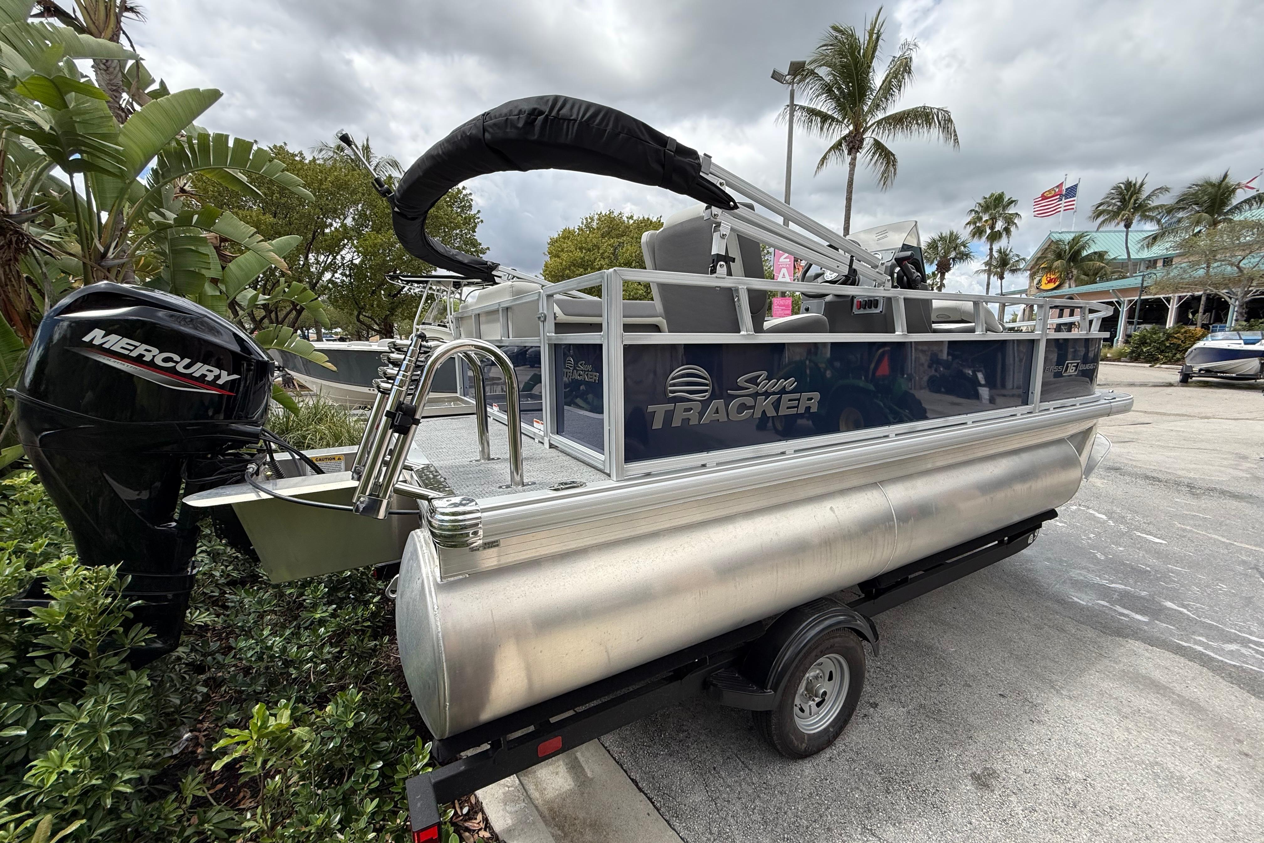 2026 Sun Tracker Bass Buggy 16 XL Select pontoon boat with Mercury engine on trailer.