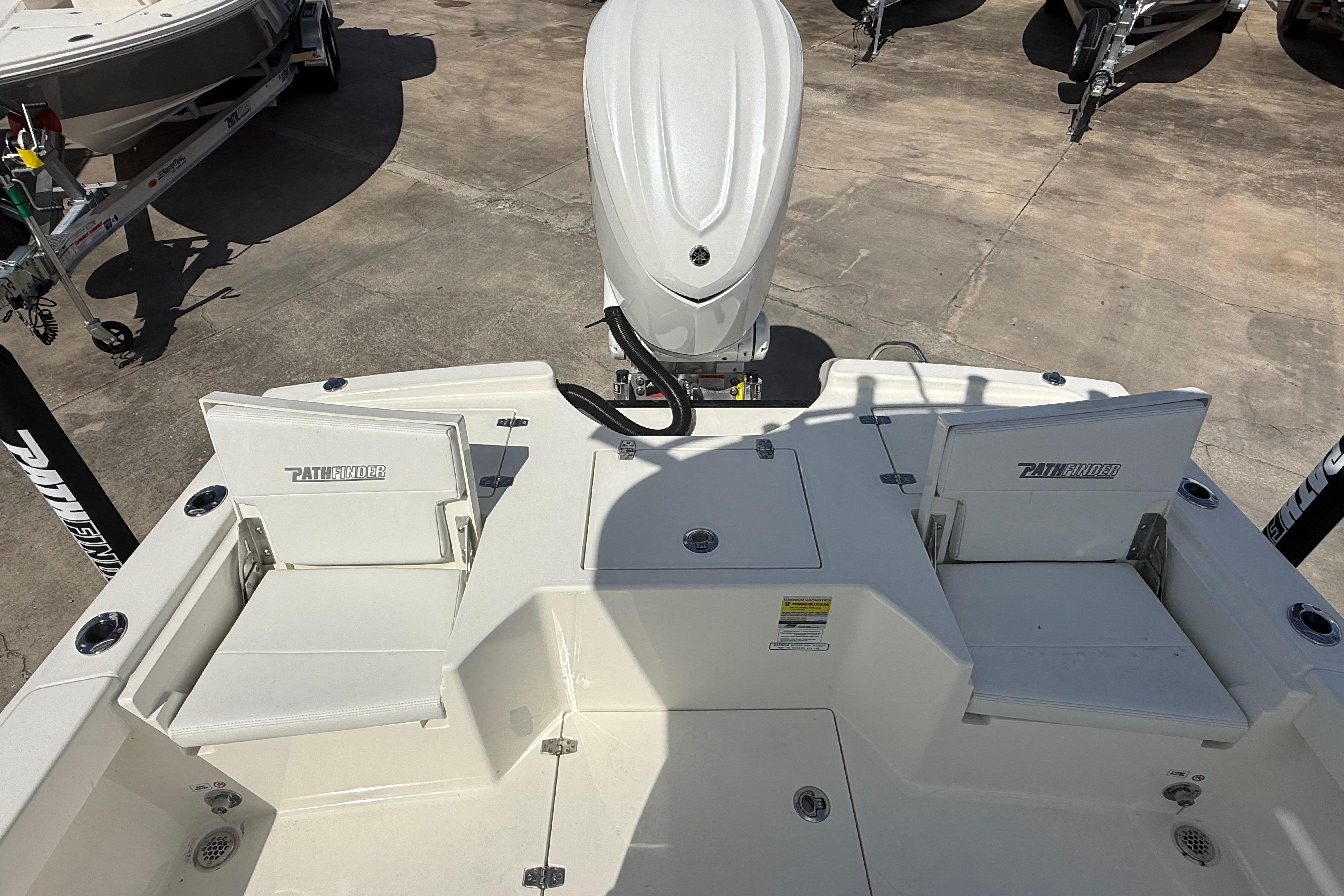 2026 Pathfinder 2500 Hybrid boat deck with seating and motor, displayed outdoors.