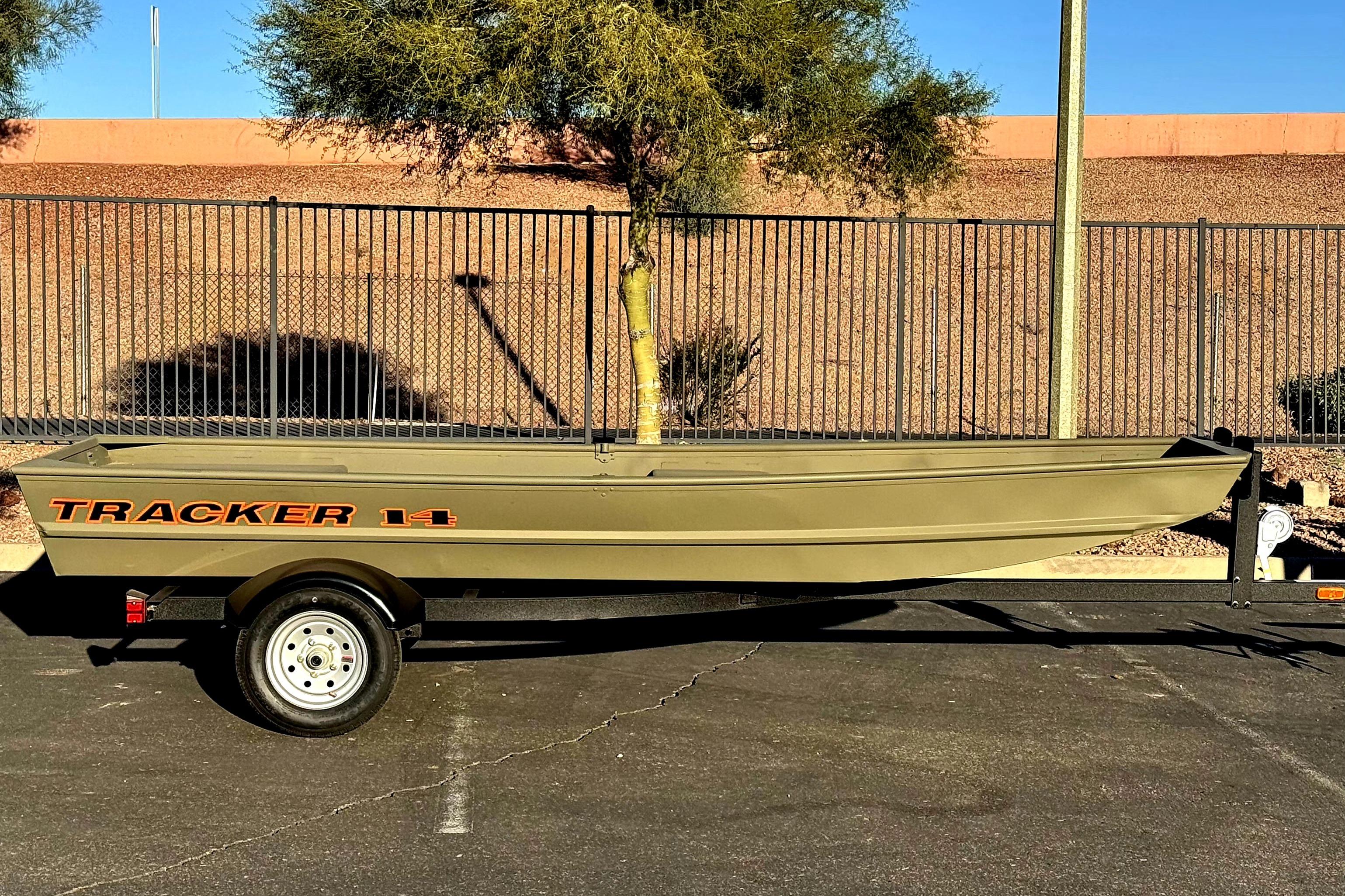 2026 Tracker Grizzly 14 Jon boat on trailer, parked outdoors.