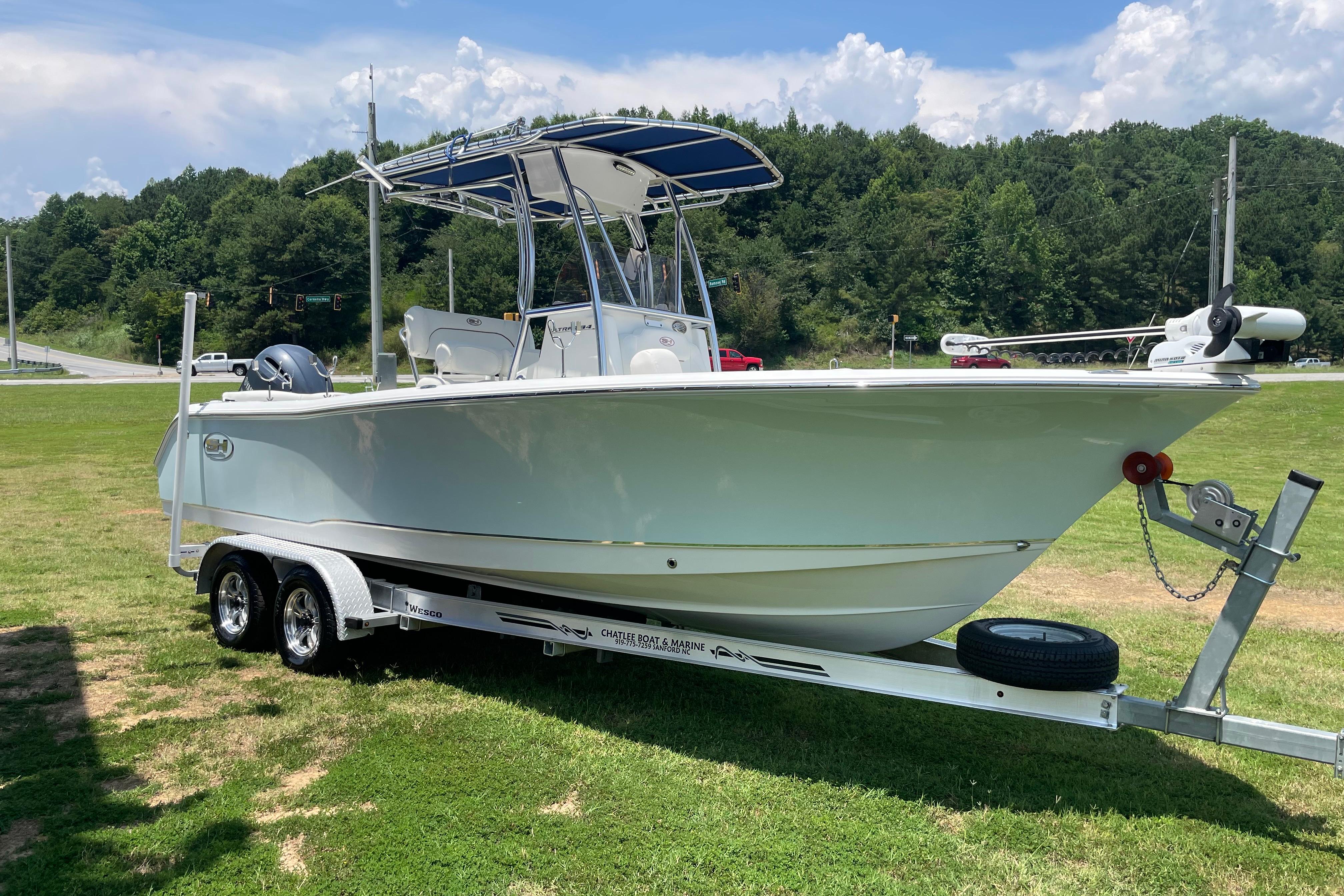 2018 Sea Hunt Ultra 234 boat on trailer, parked on grassy area.
