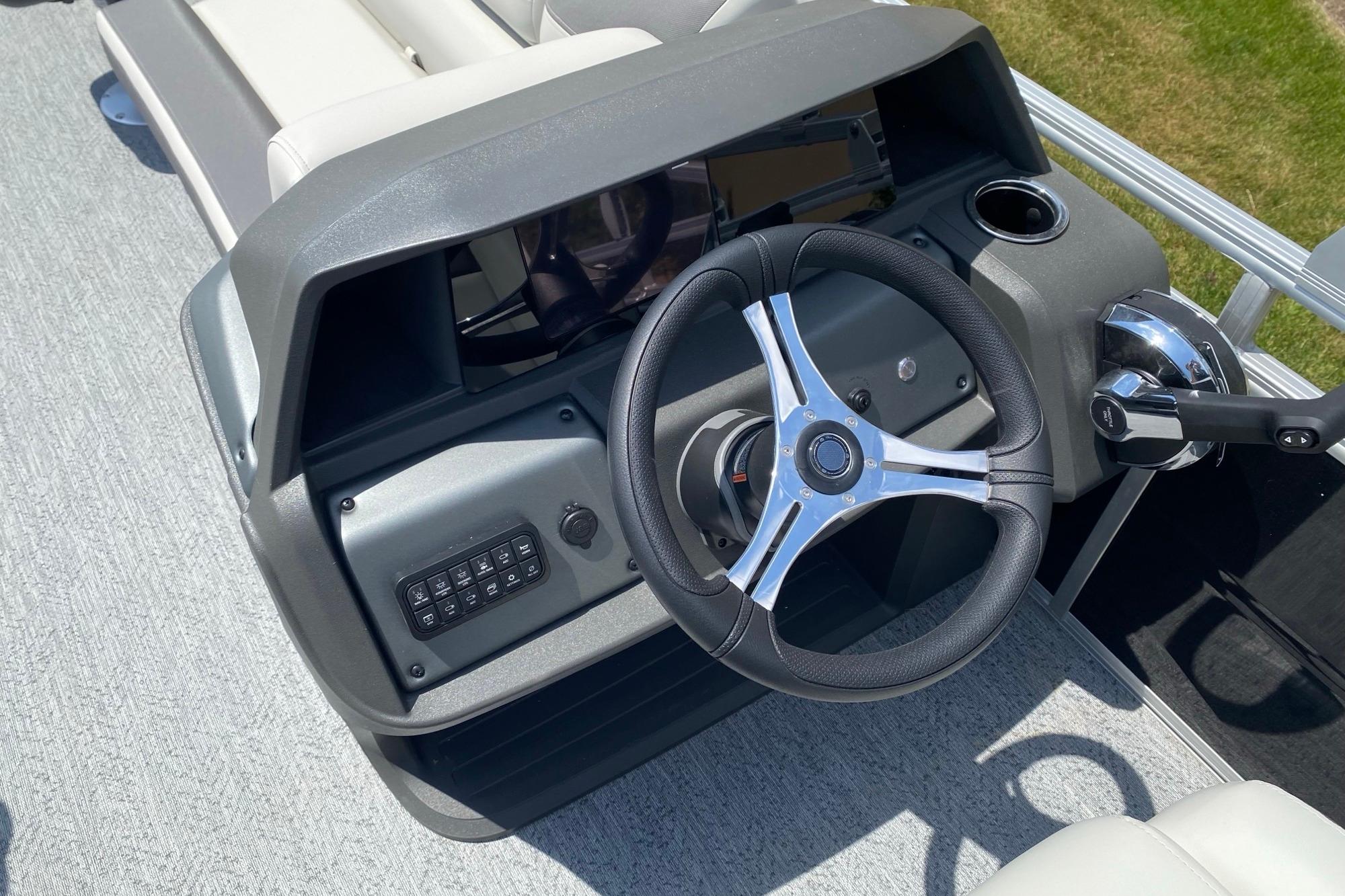 2026 Sun Tracker Fishin' Barge 20 DLX steering console with modern controls and sleek design.