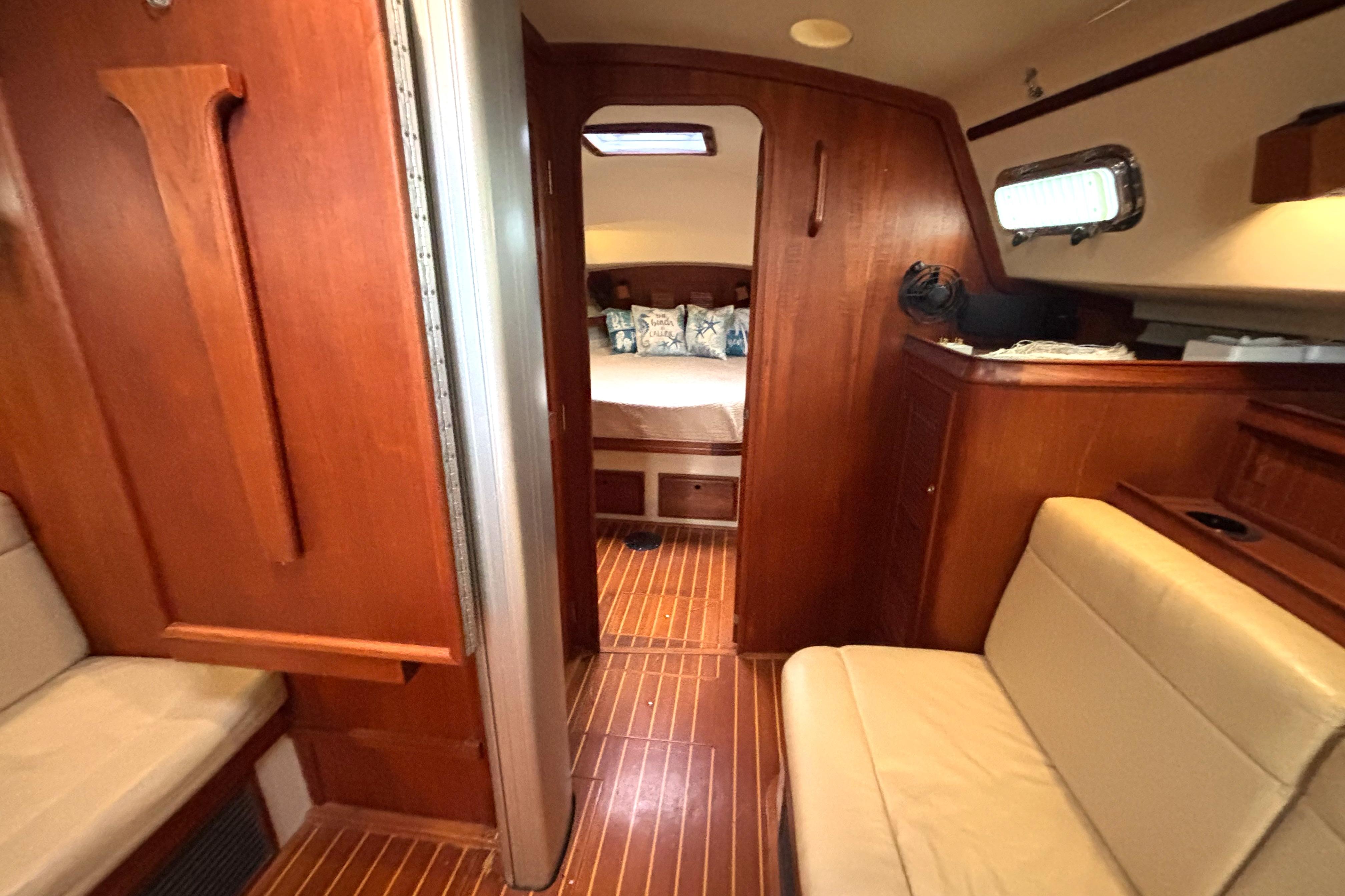Interior of 2001 Island Packet 380 sailboat with wood finish and cozy seating area.