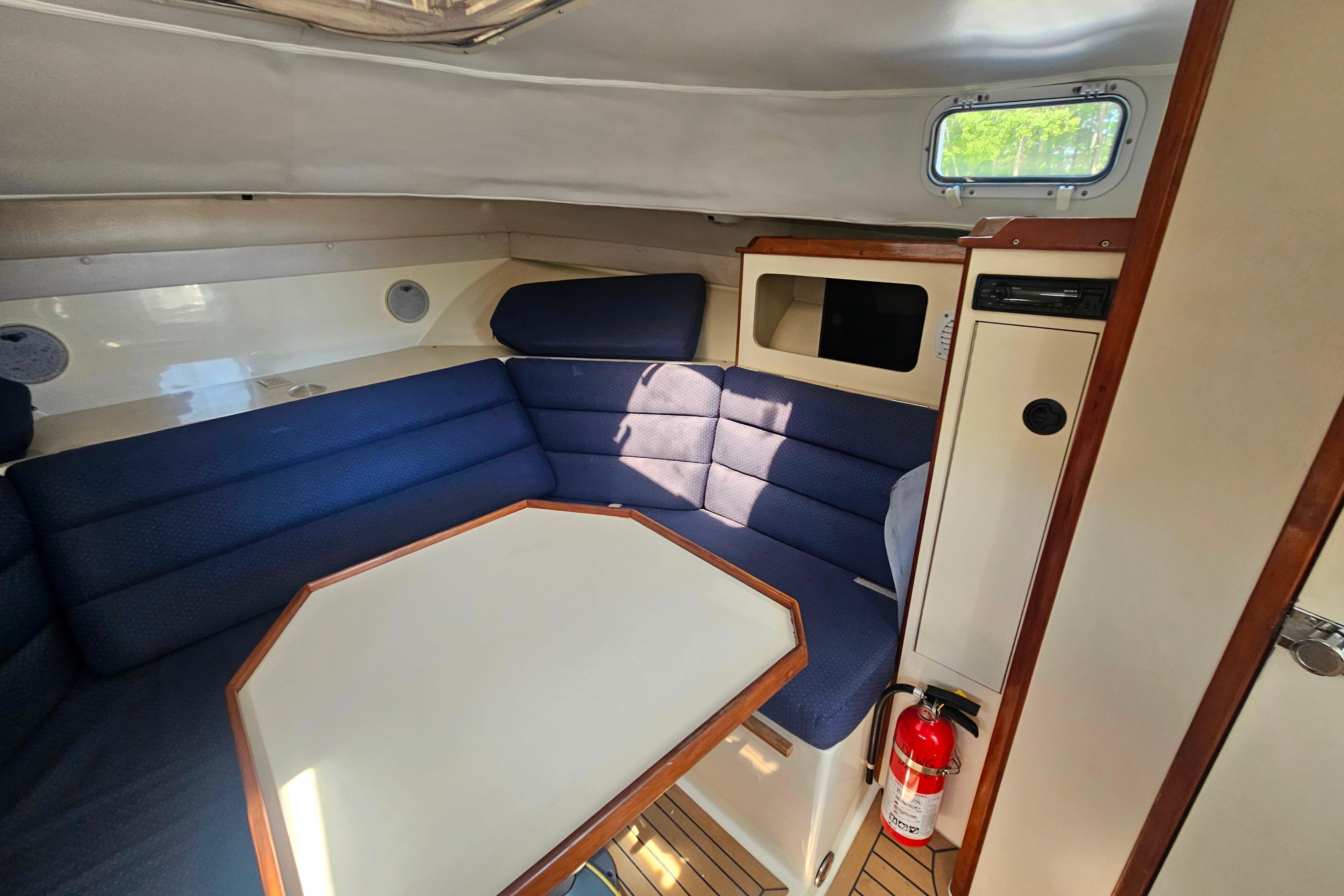 Interior of 1999 Albin 28 Tournament Express with blue seating and wooden accents.