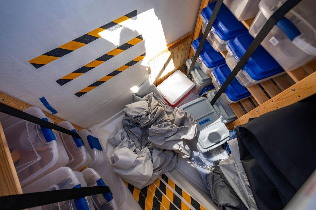 Storage area on a 2022 Leopard 53 Powercat with organized containers and safety markings.