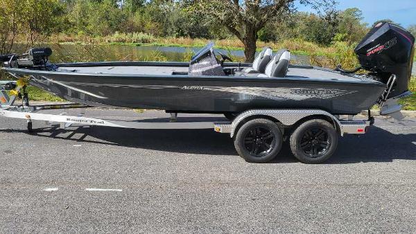2025 Ranger ALPHA 208 boat on trailer, parked on road near trees and water.