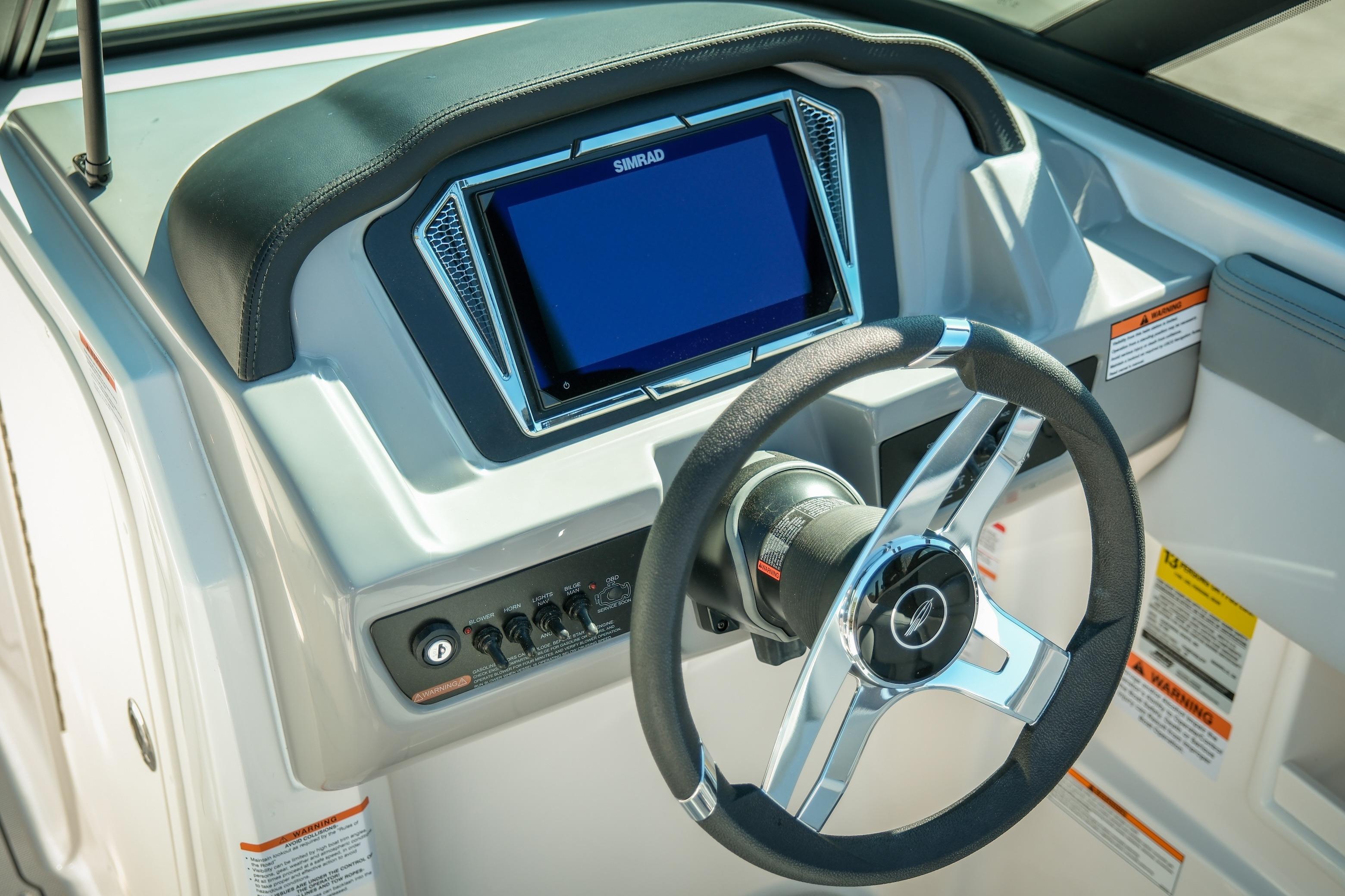 2026 Chaparral 23 SSi boat dashboard with steering wheel and Simrad display.