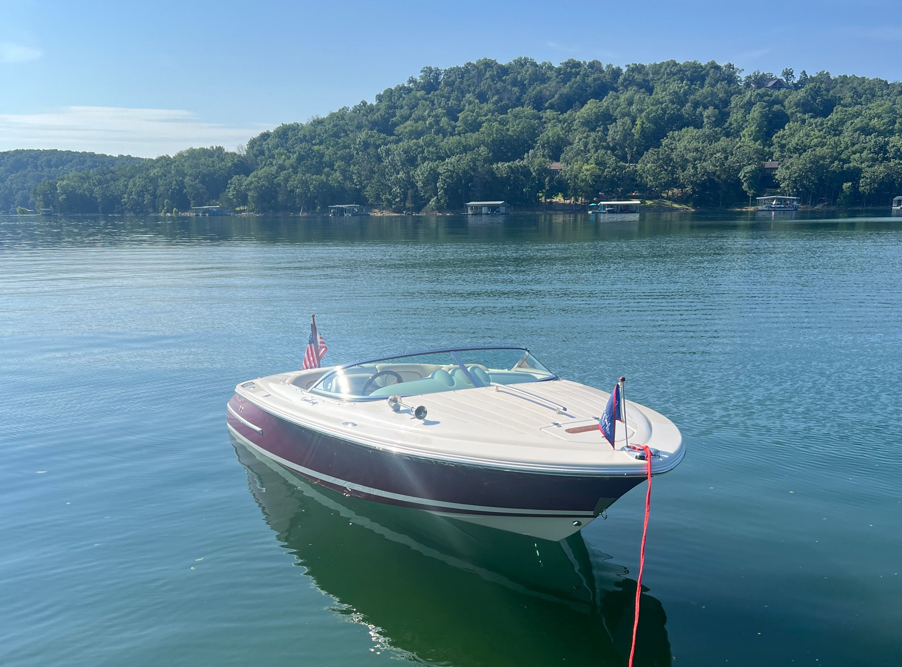 A 2006 Chris-Craft Speedster 20 is anchored on a calm lake.