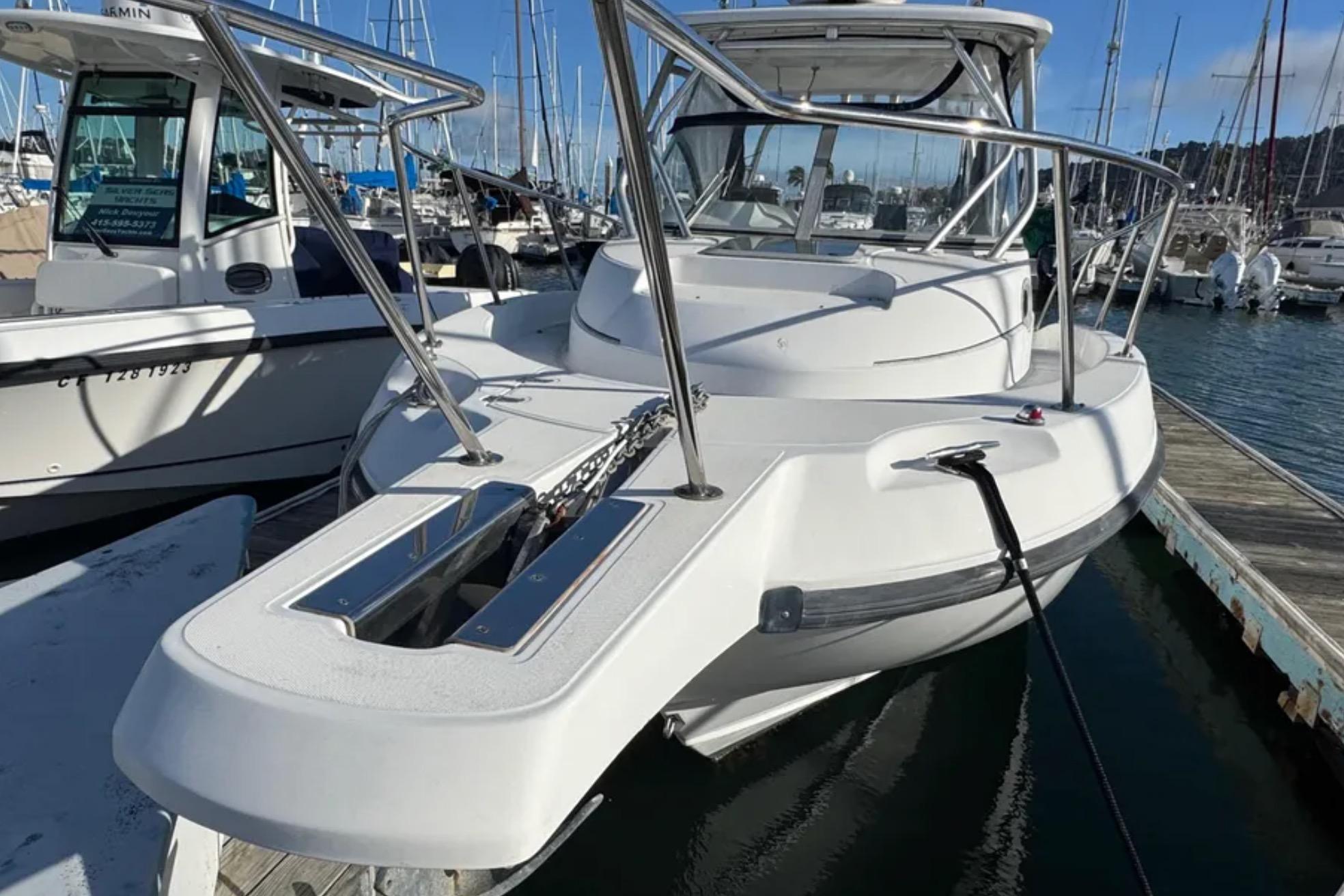 2004 Boston Whaler 255 Conquest boat docked in a marina, surrounded by other vessels.